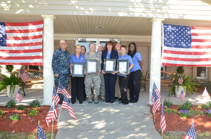 Balfour Beatty Communities on Joint Base Charleston - Weapons Station, recently received the 2013 Multifamily Real Estate Award for Customer Service Excellence, also known as the CEL & Associates “A List” Award, for all four Weapons Station neighborhoods, Nov. 14, 2013. On hand for the award presentation were (left to right) Navy Capt. Timothy Sparks, JB Charleston deputy commander and Naval Support Activity Charleston commanding officer, Balfour Beatty representatives Carla Pagan and Shelly Wolters, Col. Jeffrey DeVore, JB Charleston commander, Chief Master Sergeant Earl Hannon, 628th Airbase Wing command chief, Patti Stanley, Balfour Beatty representative, Master Chief Petty Officer Joseph Gardner, NSA Charleston command master chief, and Stephanie Newcomb and Duwanna Clement, Balfour Beatty representatives. (U.S. Navy photo by Petty Officer 2nd Class Chad Hallford)   