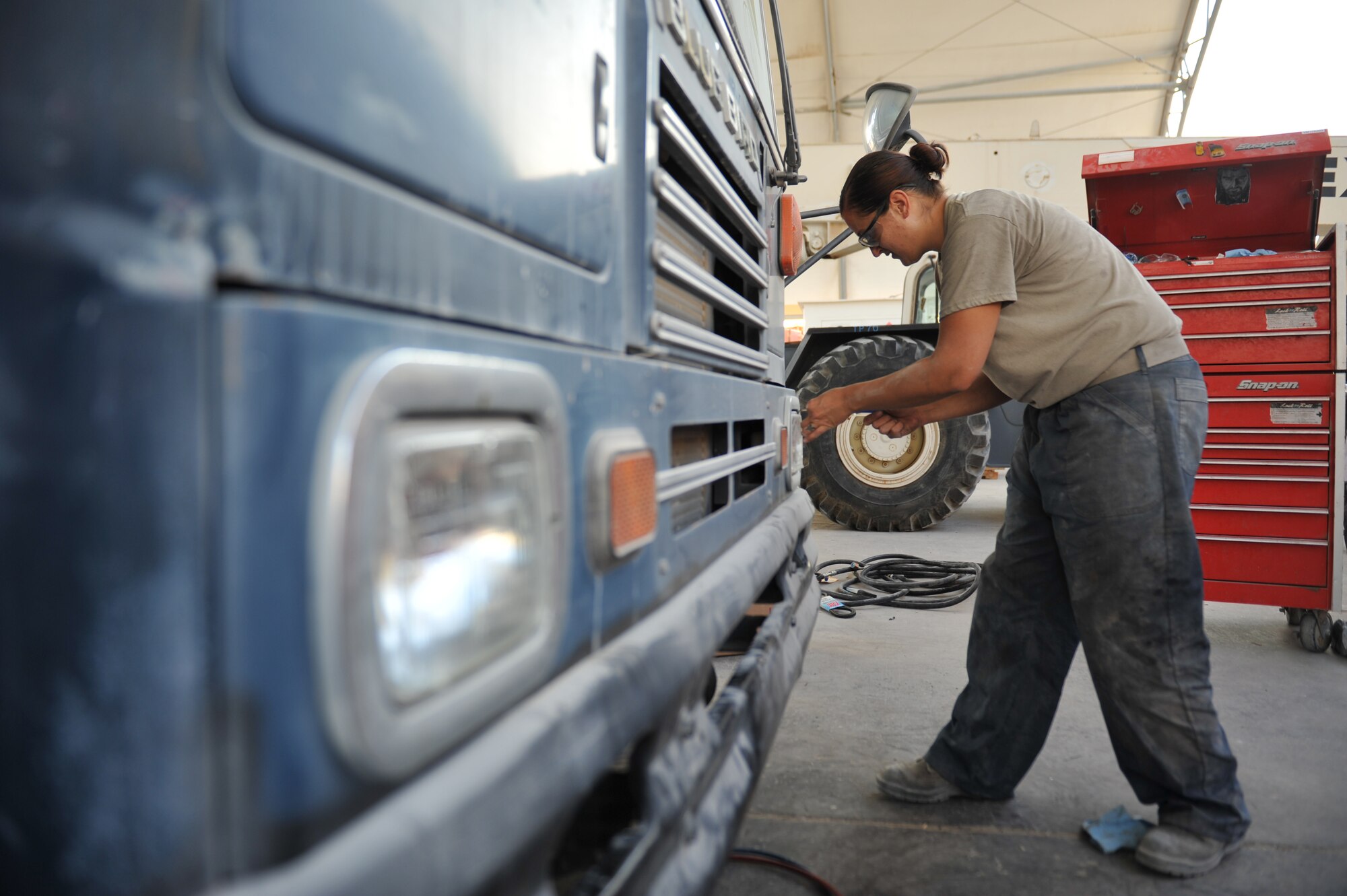 Staff Sgt. Brittany Moses replaces a bus headlight in Southwest Asia, Nov. 14, 2013. Buses provide transportation for many service members and run 24 hours a day. Moses is a 379th Expeditionary Logistics Readiness Squadron vehicle equipment journeyman on the bus team deployed from Joint Base Langley-Eustis, Va., and an Elizabethtown, Ky., native. (U.S. Air Force photo/Master Sgt. David Miller)