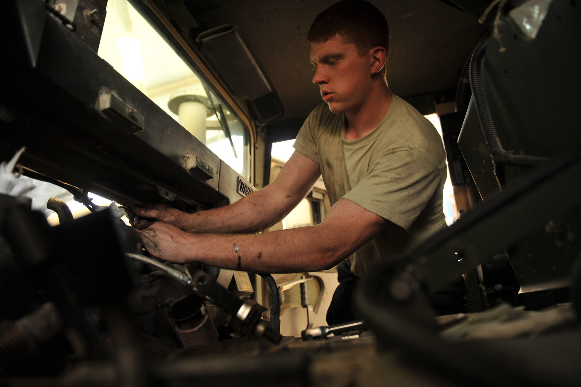 Senior Airman Joseph Stevenson works on a Humvee in Southwest Asia, Nov. 14, 2013. Humvees come in for scheduled maintenance every three months due to amount of use they receive. Stevenson is a 379th Expeditionary Logistics Readiness Squadron vehicle equipment journeyman on the Humvee team deployed from Eielson Air Force Base, Alaska, and a Canajoharie, N.Y., native. (U.S. Air Force photo/Master Sgt. David Miller)