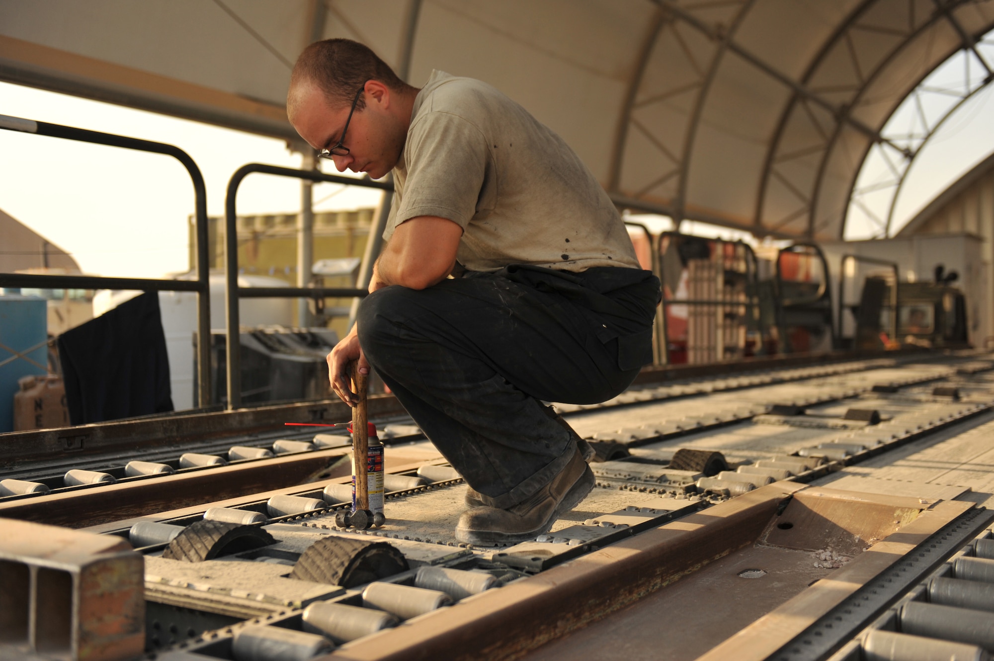 Senior Airman Caleb Delbaugh adjusts the conveyor motor on a Tunner 60K aircraft cargo loader in Southwest Asia, Nov. 14, 2013. Delbaugh is a 379th Expeditionary Logistics Readiness Squadron special vehicle maintenance journeyman assigned to the special purpose team deployed from Joint Base Charleston, S.C., and a Virginia Beach, Va., native. (U.S. Air Force photo/Master Sgt. David Miller)
