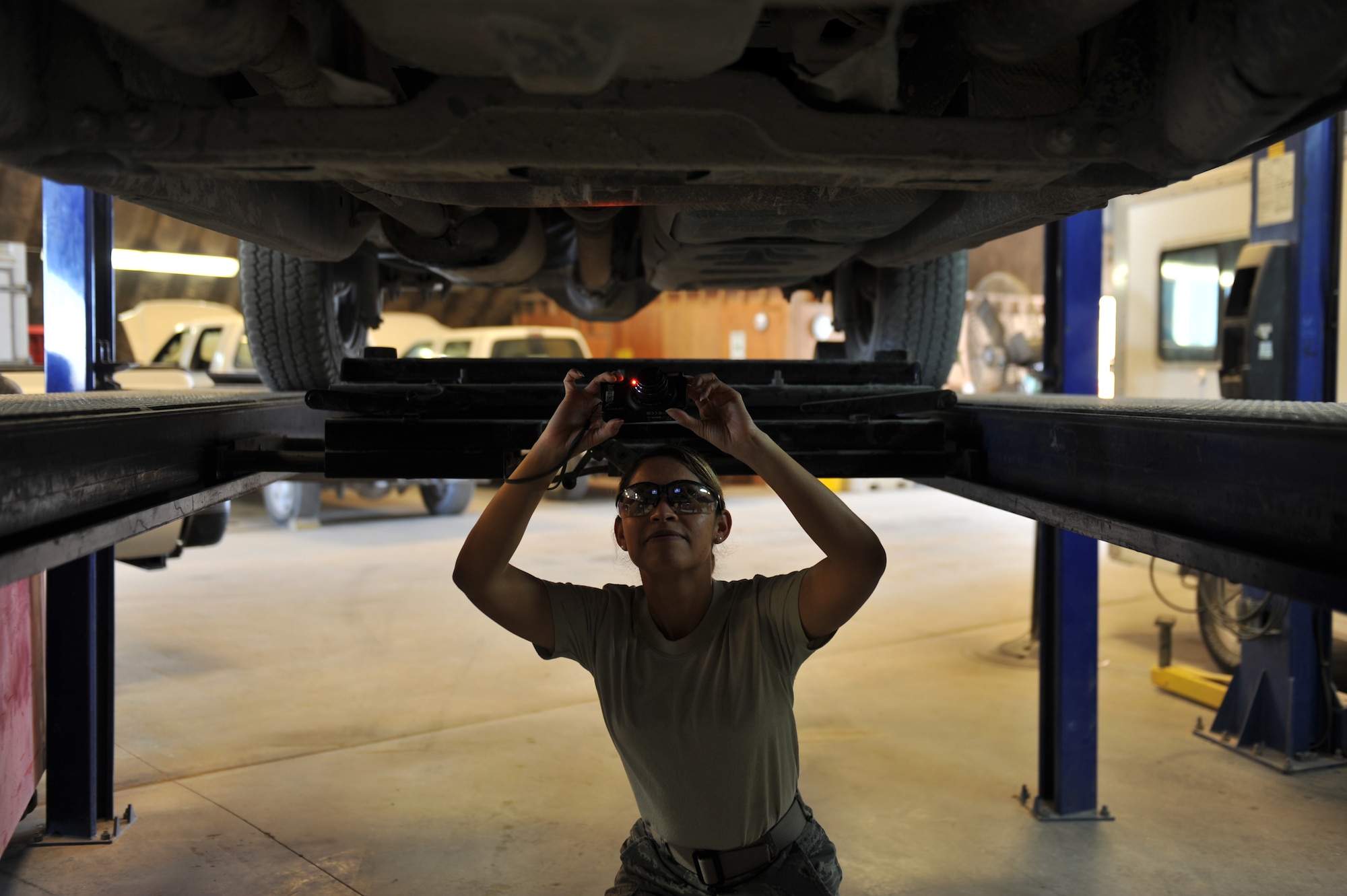 Tech. Sgt. Miriam Pestilos photographs damage to the undercarriage of a vehicle in Southwest Asia, Nov. 14, 2013. Pestilos is the 379th Expeditionary Logistics Readiness Squadron fleet manager. The fleet management section is responsible for managing and accounting for the base vehicle fleet. Pestilos is deployed from Mountain Home Air Force Base, Idaho and a Miami, native. (U.S. Air Force photo/Master Sgt. David Miller)