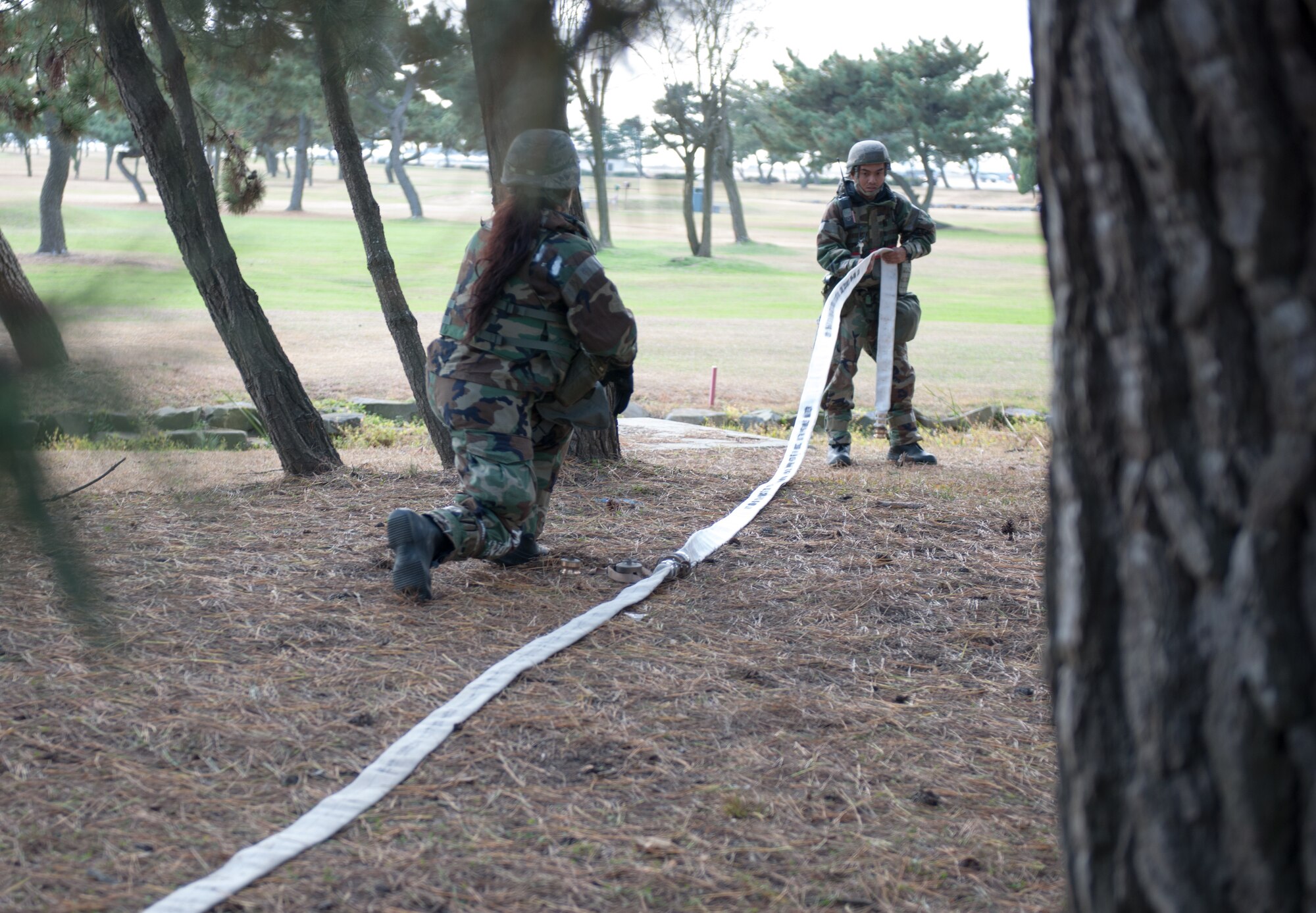 Senior Airman Jason Galang, 8th Civil Engineer Squadron water fuel systems maintenance technician, right, drags out a hose for a filtration system during Beverly Bulldog 14-01 at Kunsan Air Base, Republic of Korea, Nov. 19, 2013. Airmen from the 8th CES tested their ability to provide clean and potable water to the Wolf Pack. The 8th Fighter Wing is testing its wartime mission alongside other 7th Air Force units and supporting organizations with an emphasis on the operational and tactical levels of war during the peninsula-wide exercise. (U.S. Air Force photo by Senior Airman Armando A. Schwier-Morales)
