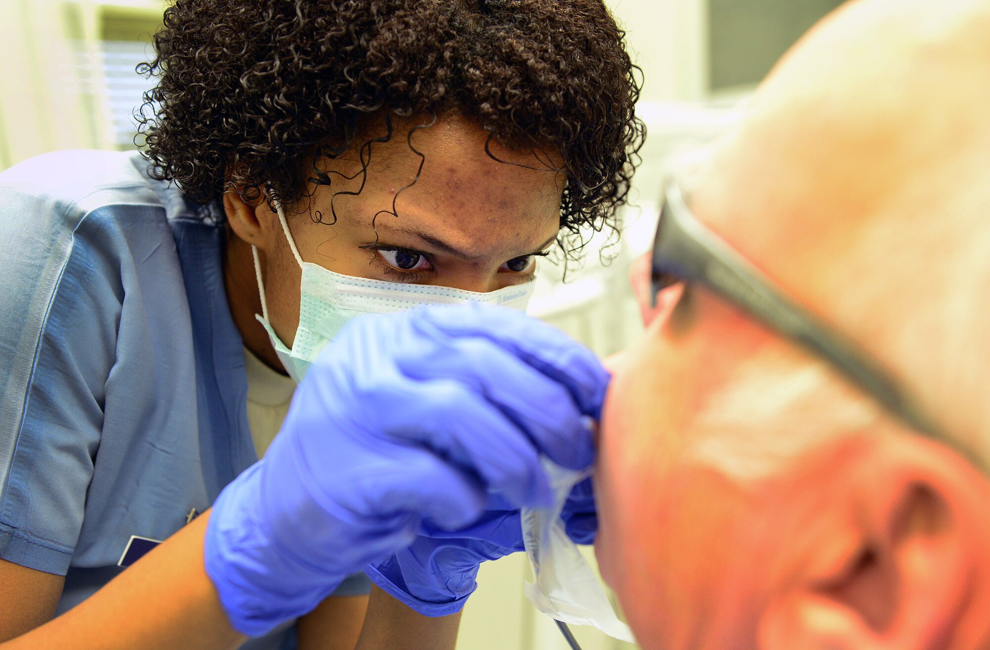 Airman 1st Class Porsha Vinson, 31st Dental Squadron technician, inspects a retiree’s teeth during Retiree Appreciation Day, Nov. 15, 2013, at Aviano Air Base, Italy. The 31st DS reserved the day for retirees and provided services that they would normally be seen on space available or emergency basis. (U.S. Air Force photo/Senior Airman Matthew Lotz)