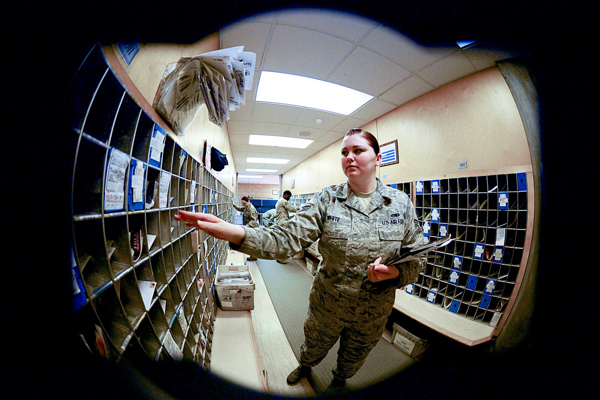 Senior Airman Ashley White, 48th Communications Squadron postal clerk, distributes mail into boxes at the Royal Air Force Lakenheath Post Office, England, Nov. 14, 2013. RAF Lakenheath postal workers have prepared for the upcoming holiday season by upgrading equipment and extending their hours. (U.S. Air Force photo by Airman 1st Class Dawn M. Weber/Released)