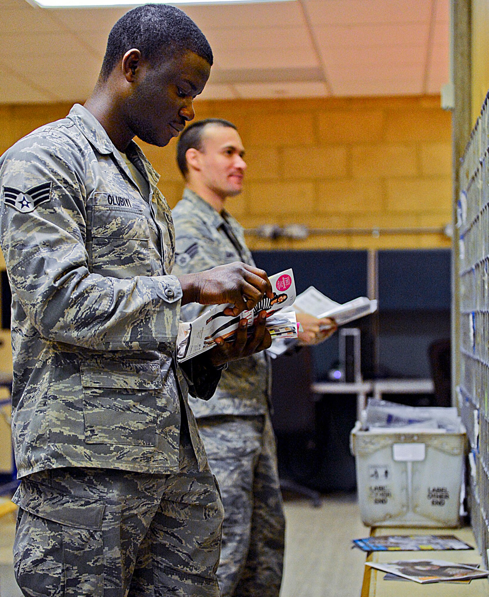 Senior Airman Victor Olubiyi, 48th Communications Squadron postal clerk, distributes mail into boxes at the Royal Air Force Lakenheath Post Office, England, Nov. 14, 2013. RAF Lakenheath postal workers have prepared for the upcoming holiday season by upgrading equipment and extending their hours. (U.S. Air Force photo by Airman 1st Class Dawn M. Weber/Released) 