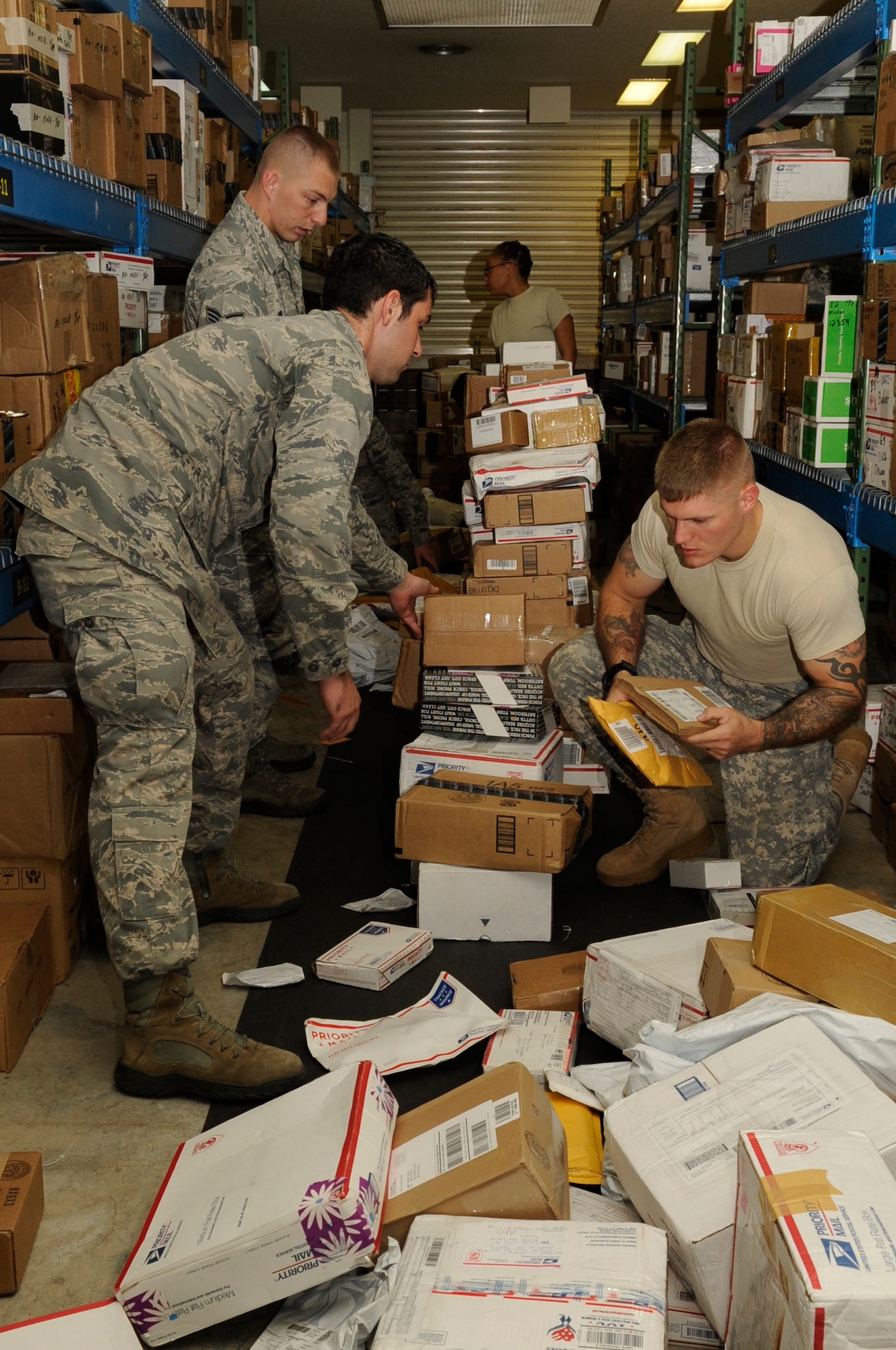 Augmentees sort packages in the post office at Kadena Air Base, Japan, Nov. 19, 2013, during the holiday season. The augmentees work 12 hour shifts sorting mail, loading and unloading trucks with packages and giving parcels to customers. (U.S. Air Force photo by Senior Airman Marcus Morris)