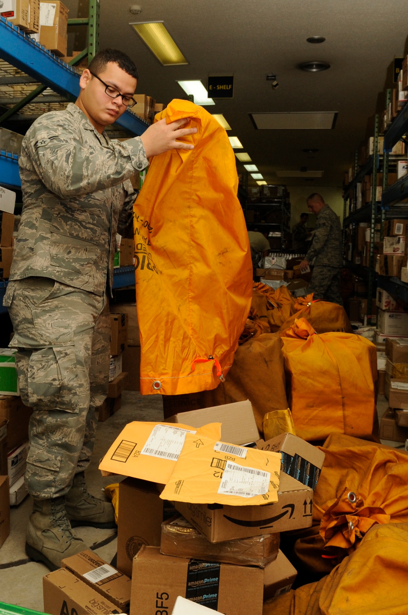 U.S. Air Force Airman 1st Class Adan Rivera Castro, 18th Munitions Squadron munitions controller and post office augmentee, unloads packages from mail bags at the post office at Kadena Air Base, Japan, Nov. 19, 2013. The augmentee’s jobs include sorting mail, loading and unloading trucks with packages and giving parcels to customers. (U.S. Air Force photo by Senior Airman Marcus Morris)