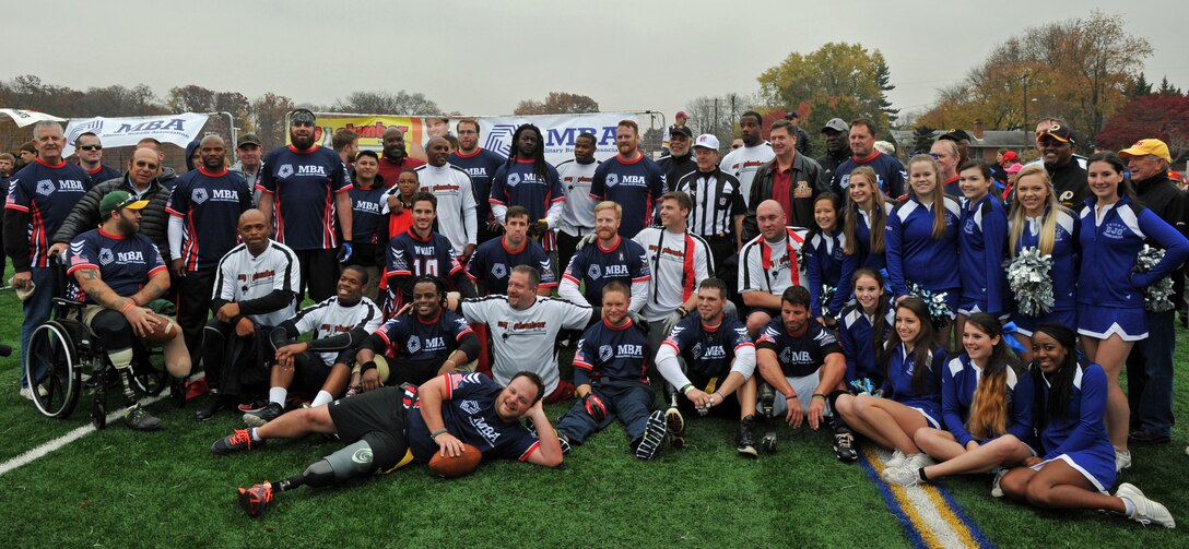 All in a day's fun, the Wounded Warrior Amputee Football Team mixes with NFL and Washington Redskins alumni and Bishop O'Connell High School cheerleaders at Bishop O'Connell High School in Arlington, Va., Nov. 16, 2013. A flag football game sponsored by the nonprofit Military Benefit Association raised $60,000 for the amputees. U.S. Army photo by J.D. Leipold