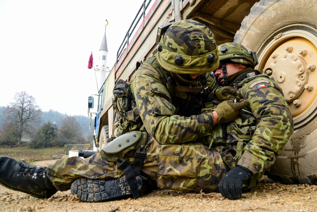 A Czech soldier provides first aid to fellow soldiers during attack training as part of exercise Combined Resolve at the Joint Multinational Readiness Center, Hohenfels, Germany, Nov. 15, 2013.
