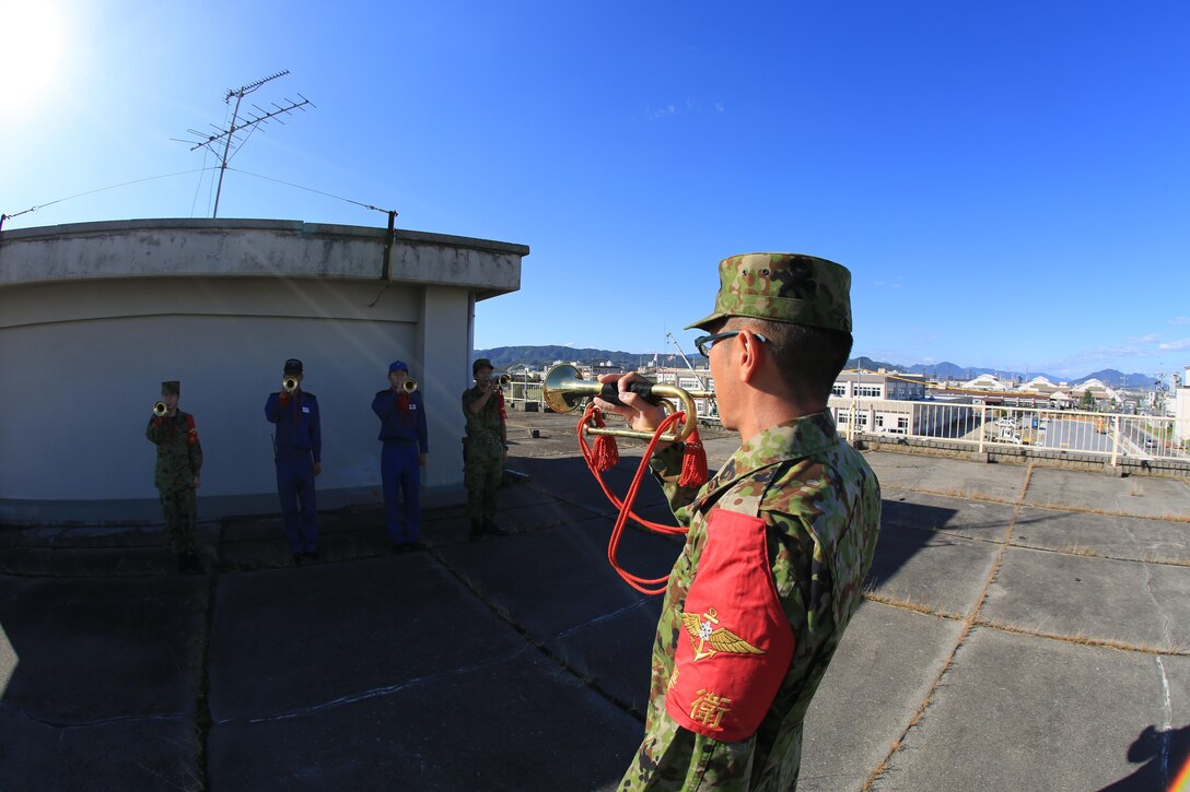 Petty Officer 3rd Class Takuya Izumi, Japan Maritime Self-Defense Force service member, bugle player and conductor, leads four bugle players in playing different notes aboard Marine Corps Air Station Iwakuni, Japan, Sept. 26, 2013. All JMSDF service members from ground rescue, color guard and motor transportation units are required to learn how to play the bugle.