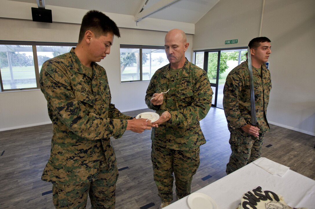 Lance Cpl. Ryo Bolanos, the youngest Marine and a forward observer with 1st Air Naval Gunfire Liaison Company ceremoniously receives cake from Chief Warrant Officer 4 Gordon Butler, oldest Marine and motor transport officer with Combat Logistics Regiment 15, from Greenbush, Minn., at the 238th Marine Corps birthday celebration during exercise Southern Katipo 2013 aboard Linton Military Camp, New Zealand, Nov. 10. SK13 is designed to improve participating forces’ combat training, readiness and interoperability as part of a Joint Inter-Agency Task Force. 