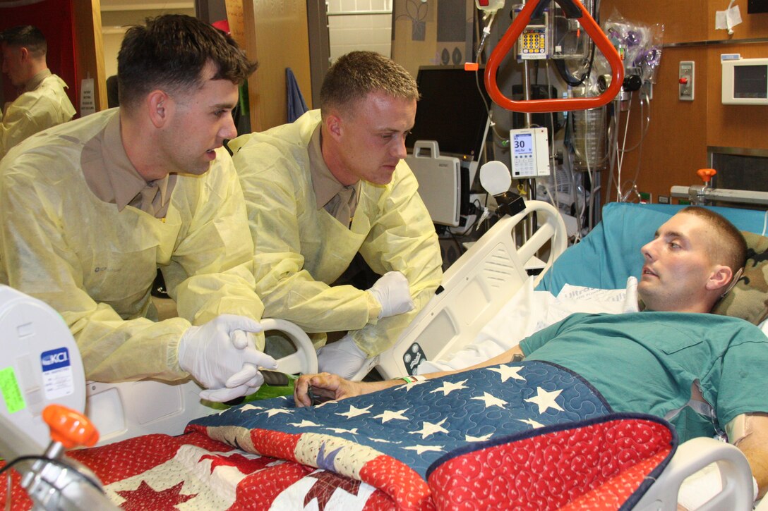 Cpl. Christian Brown talks with his Marine brothers from Company B, 1st Battalion, 6th Marine Regiment, during their visit to Walter Reed National Military Medical Center on Feb. 16, 2012. Coordinating with friends and family is perhaps Wounded Warrior Regiment’s  most important task while wounded Marines are still stabilizing under the care of Navy doctors. 