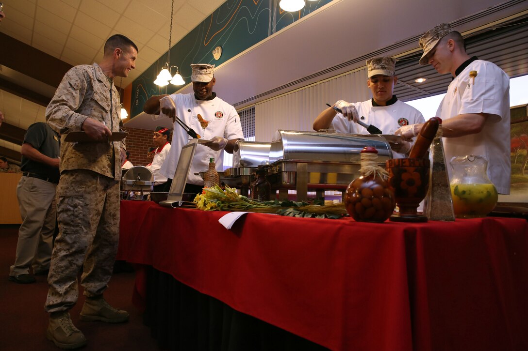 From left, Col. Christoper Edwards, head of the Quantico Logistics Division and one of the cookoff judges, gets his sampling from the Marine Corps team of Sgt. Gary King, Sgt. Erik GironGuerrero and Sgt. Austin Nelson. The Oct. 30 cookoff at Bruce Hall pitted this team against two teams of chow hall cooks. 