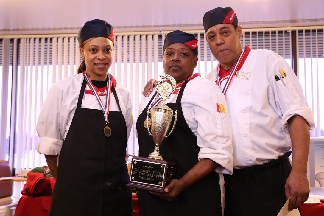 Stephanie Parker, Triege “Deedee” Heck, and John Wardrick, team one, pose with the first place trophy at the Culinary Team of the Quarter Cook-Off at Bruce Hall on Oct. 30, 2013. 