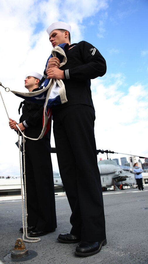 Sailors aboard the USS New York prepare to the post the National ensign at the aft end of the ship, signifying the ship reaching port Nov. 8, 2013. The ship ported in New York City for Veterans Day weekend, and was open to the public during its stay, so civilians could tour the vessel. 