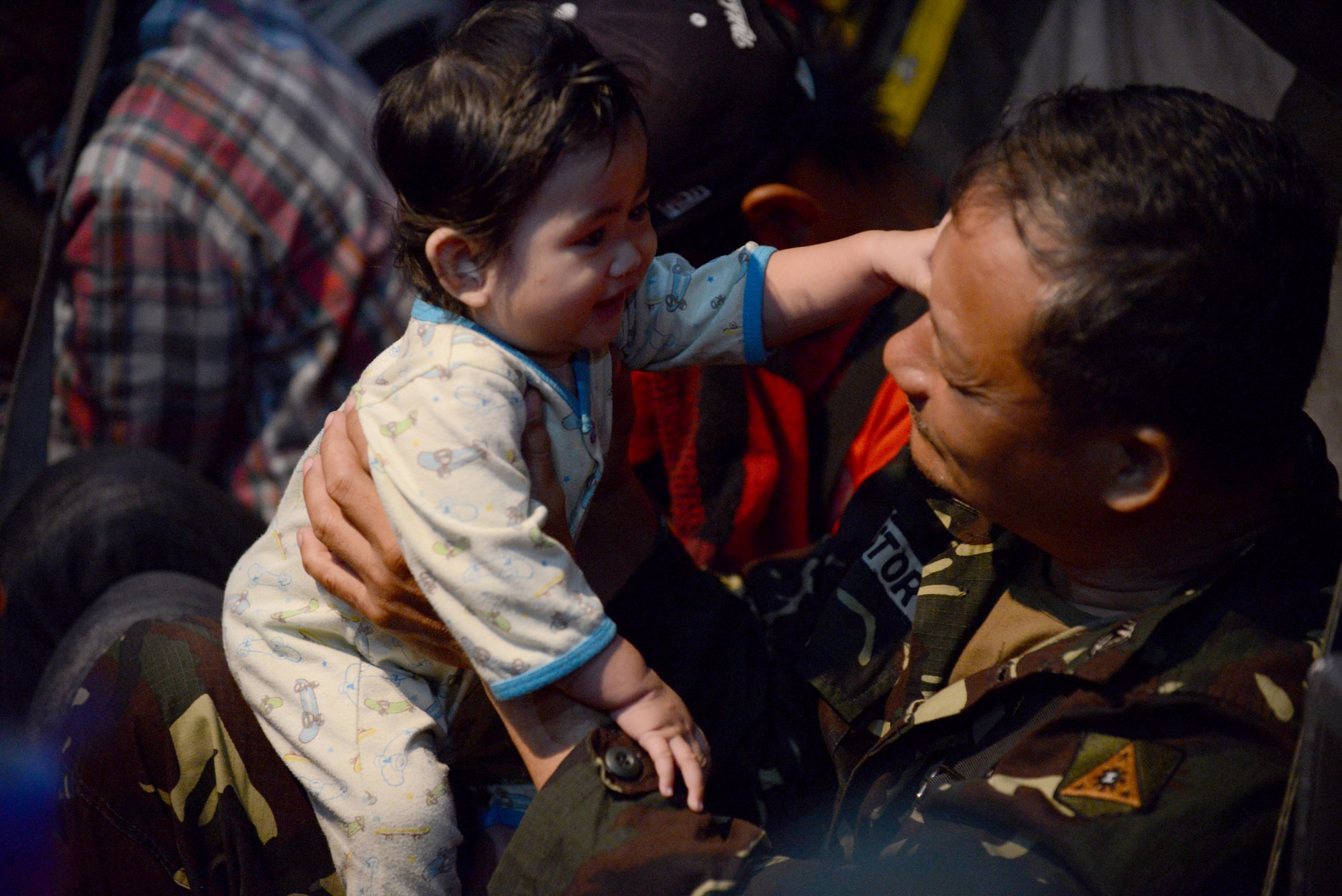 A Philippine army soldier comforts a baby on an Air Force C-130 Hercules aircraft Nov. 19, 2013, during an evacuation mission in support of Operation Damayan at Villamor Air Base, Republic of the Philippines. Operation Damayan is a humanitarian aid and disaster relief operation led by the Philippine government and supported by a multinational response force.