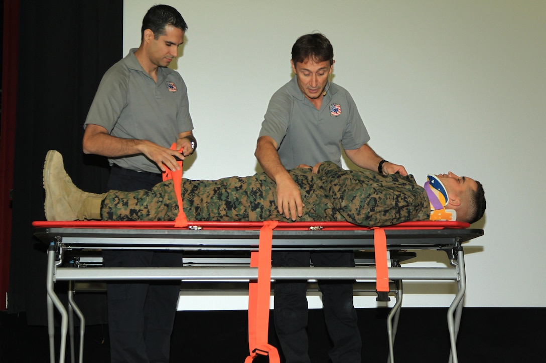 Vincent Easevoli and Oscar Duran, firefighter paramedics, Stay Alive From Education Program, use Private First Class Trevor Mixon, student, Marine Corps Communcations-Electronics School, to explain the lifesaving process taken after a vehicle accident to educate MCCES students about safe driving at the base theater Nov. 19, 2013.


