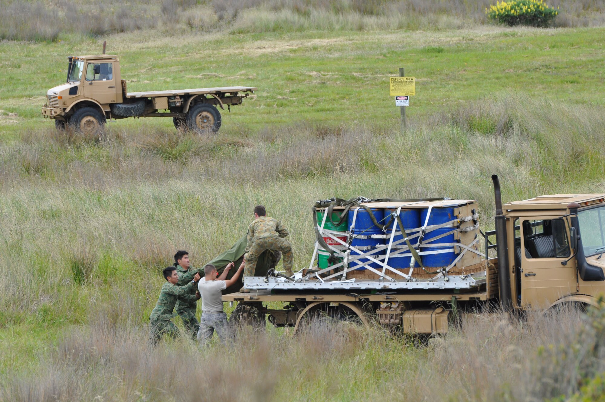 OHAKEA, New Zealand -- Republic of Singapore Armed Forces and United States Air Force personnel lift a recently-recovered main parachute to a Royal Australian Air Force team member during a combined cargo air-drop operation supporting Exercise Kiwi Flag Nov. 14 at the New Zealand Defence Force Raumi Drop Zone near Ohakea, New Zealand. Kiwi Flag is a multilateral Royal New Zealand Air Force-sponsored tactical airlift exercise comprising air assets from the USAF, RNZAF, RAAF, RSAF and French Armed Forces of New Caledonia. Kiwi Flag personnel are supporting Exercise Southern Katipo -- held on New Zealand’s South Island. (U.S. Air Force photo by Senior Master Sgt. Denise Johnson/Released)