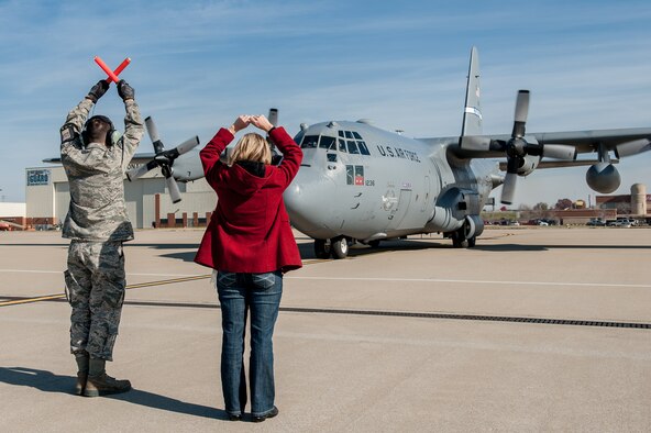 Heather Wilson, wife of Kentucky Air National Guard C-130 pilot Lt. Col. Scott Wilson, marshals his aircraft on the flight line of the 123rd Airlift Wing in Louisville, Ky., on Nov. 20, 2013. Wilson, who has served in the U.S. Air Force and Air National Guard for 26 years, is set to retire Jan. 31, 2014, and was completing his final flight in the C-130. (U.S. Air National Guard photo by Maj. Dale Greer)