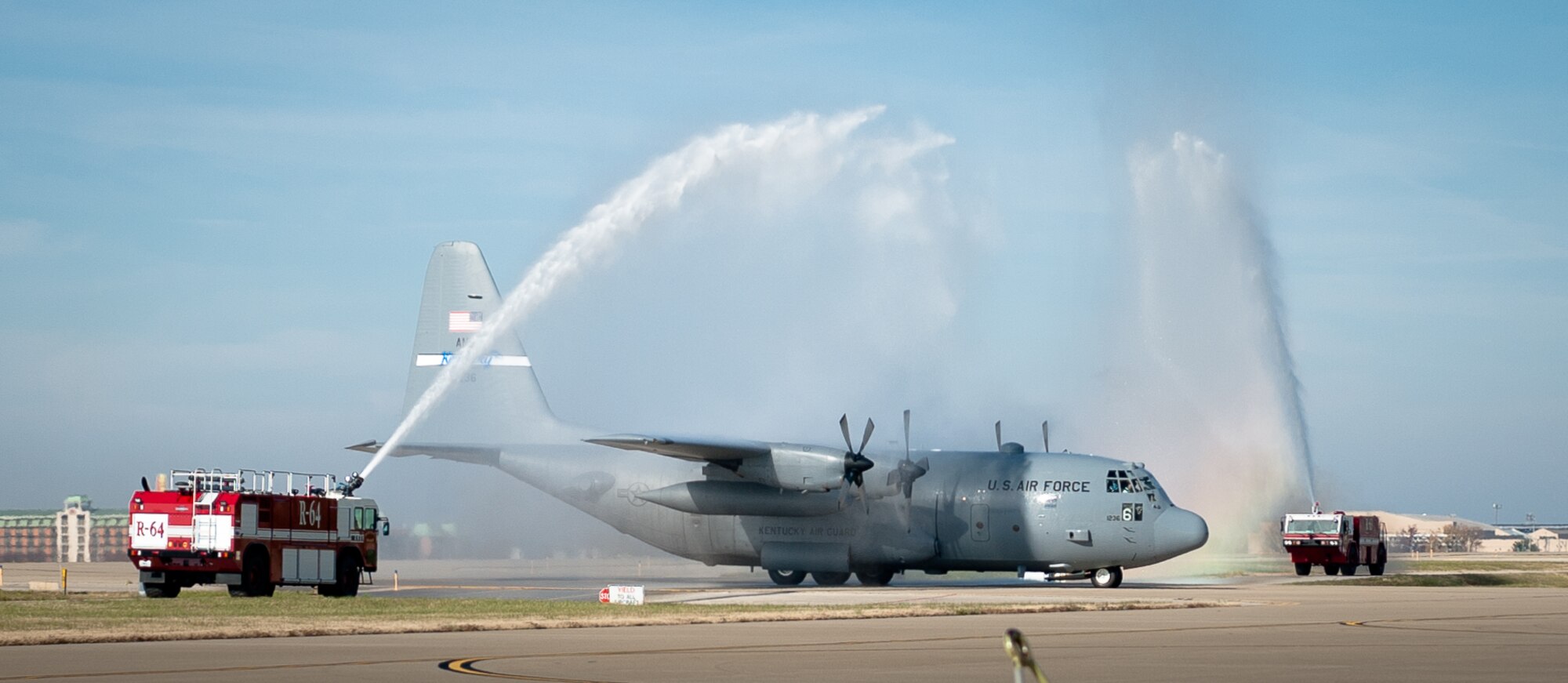 Fire trucks spray a symbolic salute at the Kentucky Air National Guard Base in Louisville, Ky., as a C-130 Hercules aircraft piloted by Lt. Col. Scott Wilson taxies to its parking spot Nov. 20, 2013. Wilson, who is set to retire Jan 31, 2014, was completing his final, or “fini,” flight in the C-130. (U.S. Air National Guard photo by Maj. Dale Greer)