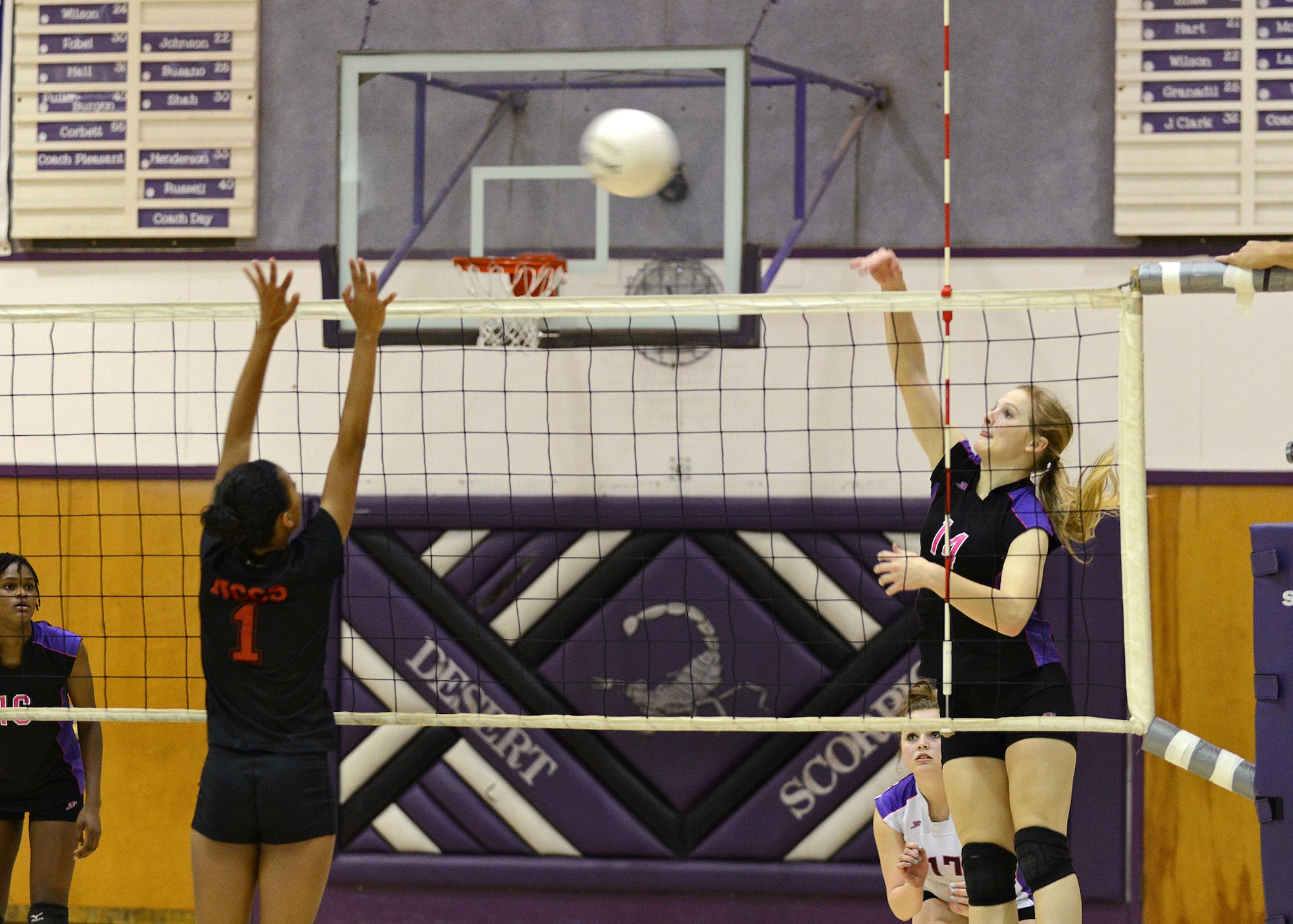Desert High School hitter Miranda Brater, #14, jumps up for a kill against a North City Christian School blocker during a California Interscholastic Federation playoff game Nov. 14 while DHS libero Victoria Rush, #17, looks on. The DHS scorpions advanced to the CIF quarter finals where they fell to Pomona Catholic High School after 3 sets Nov. 16 in Pomona, Calif. The team finished their season with a league record of 12-2 and overall record of 18-5. (U.S. Air Force photo by Jet Fabara)