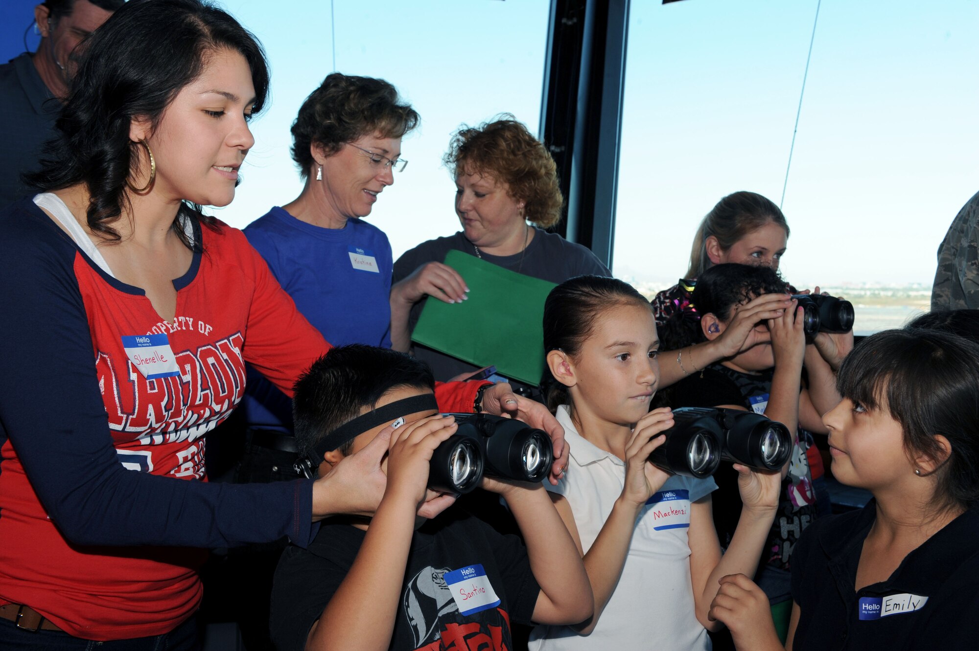 Parents and teachers help students from the Arizona School for the Deaf and the Blind, Tucson campus, look through binoculars while touring the Air Traffic Control Tower cab at Davis-Monthan Air Force Base, Ariz., Nov. 14, 2013. The students that participated in the tour attend local public schools, but receive additional, on-site training from ASDB teachers. (U.S. Air Force photo by Airman 1st Class Saphfire Cook/released) 