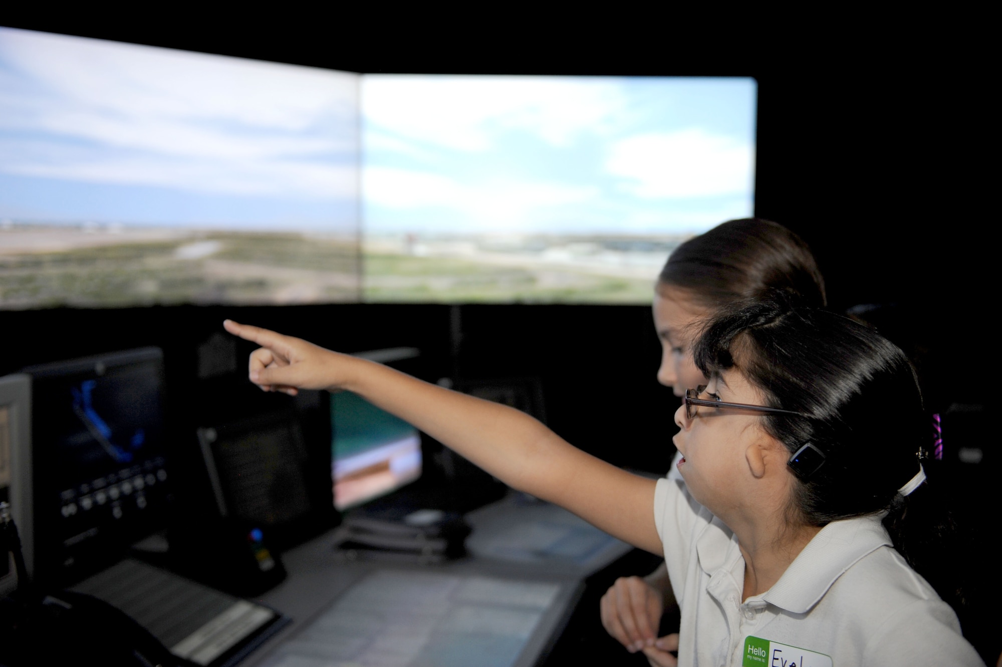 Evelyn Chavarin, Arizona School for the Deaf and the Blind third grade student, points out moving aircraft on the screen of the air traffic control tower simulator during a tour for students of the ASDB, Tucson campus, at Davis-Monthan Air Force Base, Ariz., Nov. 14, 2013. Ten students with hearing impairments, accompanied by a few teachers and parents, were given a tour of an A-10 and shown the air traffic control tower, to include the simulator. (U.S. Air Force photo by Airman 1st Class Saphfire Cook/released) 