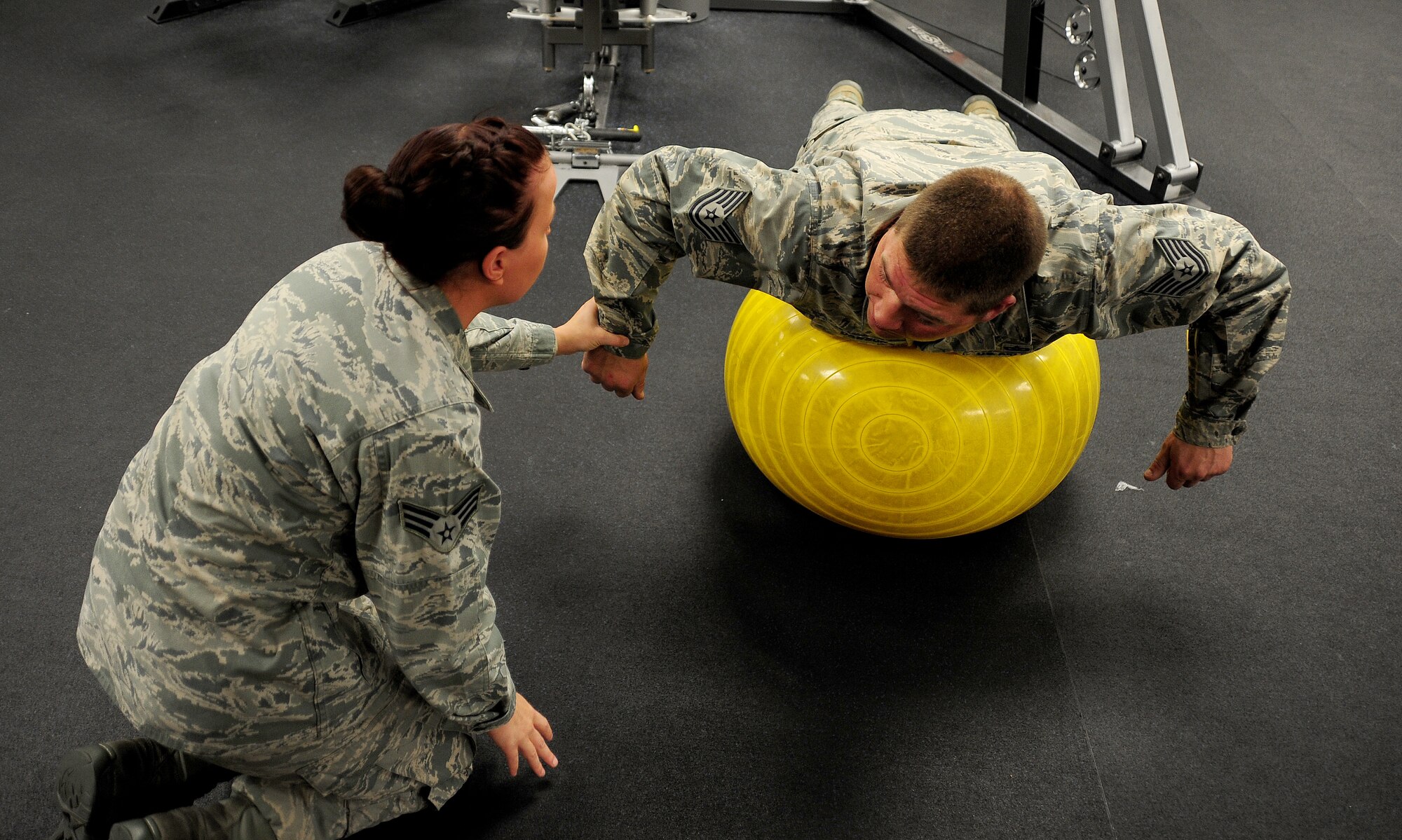 U.S. Air Force Senior Airman India Meserve, 509th Medical Operations Squadron physical therapy technician, provides assistance to U.S. Air Force Tech. Sgt. Thomas Dawson, 509th Civil Engineer Squadron, during a physical therapy exercise session at Whiteman Air Force Base, Mo., Nov. 8, 2013. Air Force physical therapists are responsible for helping to maintain the health and readiness of active-duty, Guard and Reserve Airmen. (U.S. Air Force photo by Staff Sgt. Nick Wilson/Released)