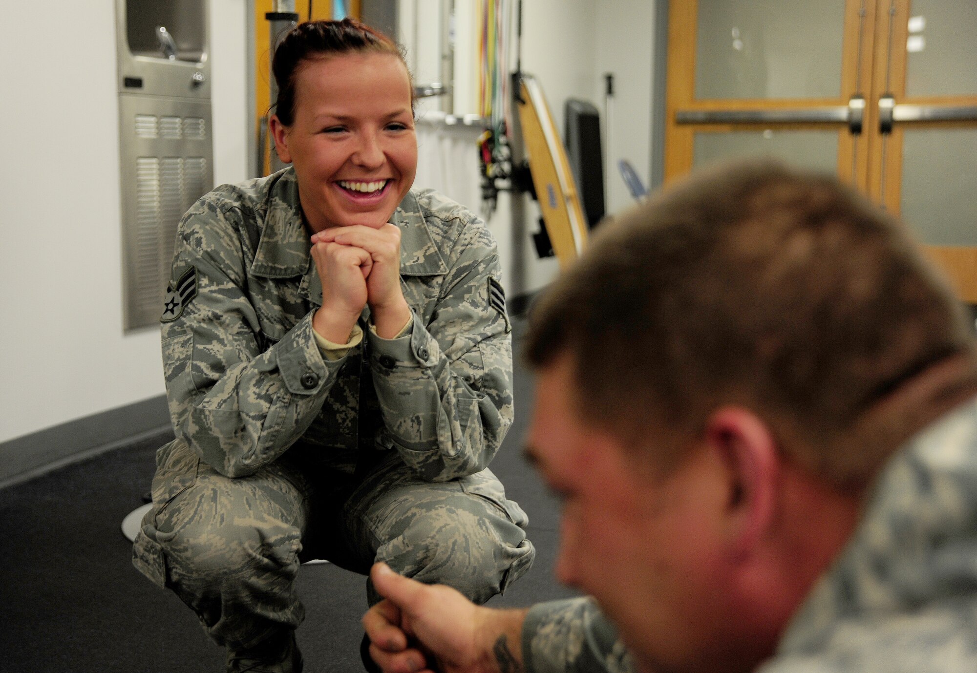 U.S. Air Force Senior Airman India Meserve, 509th Medical Operations Squadron physical therapy technician, shares a laugh with U.S. Air Force Tech. Sgt. Thomas Dawson, 509th Civil Engineer Squadron, during a physical therapy exercise session at Whiteman Air Force Base, Mo., Nov. 8, 2013. Meserve enlisted in the Air Force at the age of 17 and has been a physical therapy technician at Whiteman for more than four years. (U.S. Air Force photo by Staff Sgt. Nick Wilson/Released)