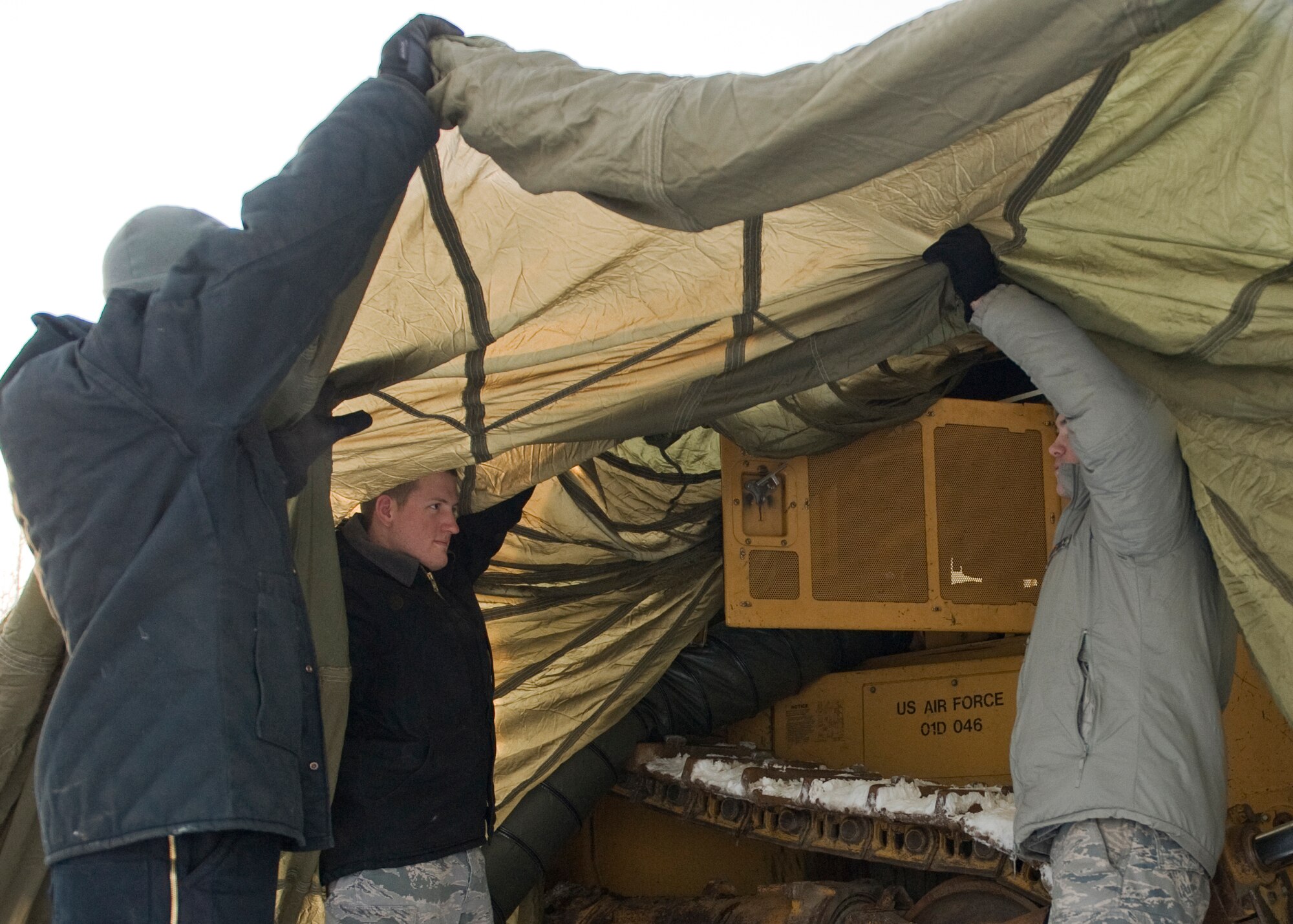 Members of the 354th Logistics Readiness Squadron vehicle maintenance shop discuss how to move a broken bulldozer indoors to perform repairs Nov. 19, 2013, Eielson Air Force Base, Alaska. Due to extreme weather conditions, vehicle maintainers have to be extra careful to avoid frostbite while working on vehicles out in the elements. (U.S. Air Force photo by Senior Airman Ashley Nicole Taylor/Released)