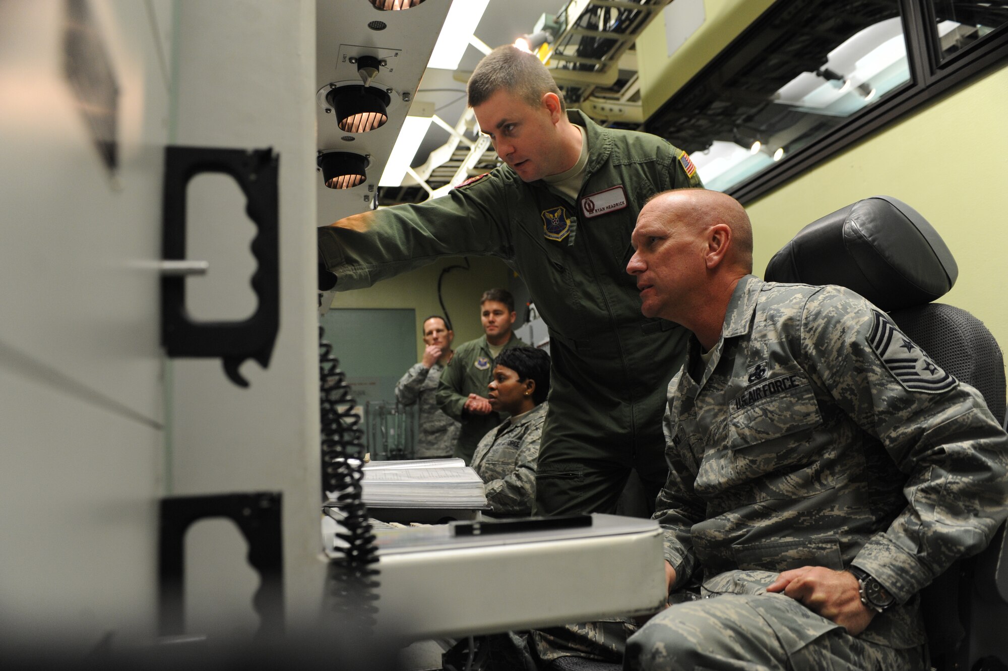 Chief Master Sgt. Brian Hornback, command chief for Air Force Global Strike Command, speaks with 1st Lt. Ryan Headrick, 91st Operational Support Squadron, in the missile training facility at Minot Air Force Base, N.D., Nov. 18. Hornback worked alongside Chief Master Sgt. Fay Noi,l 91st Missile Wing command chief, as part of two-person team to accomplish a “key turn” simulation. (U.S. Air Force photo/Senior Airman Stephanie Sauberan)