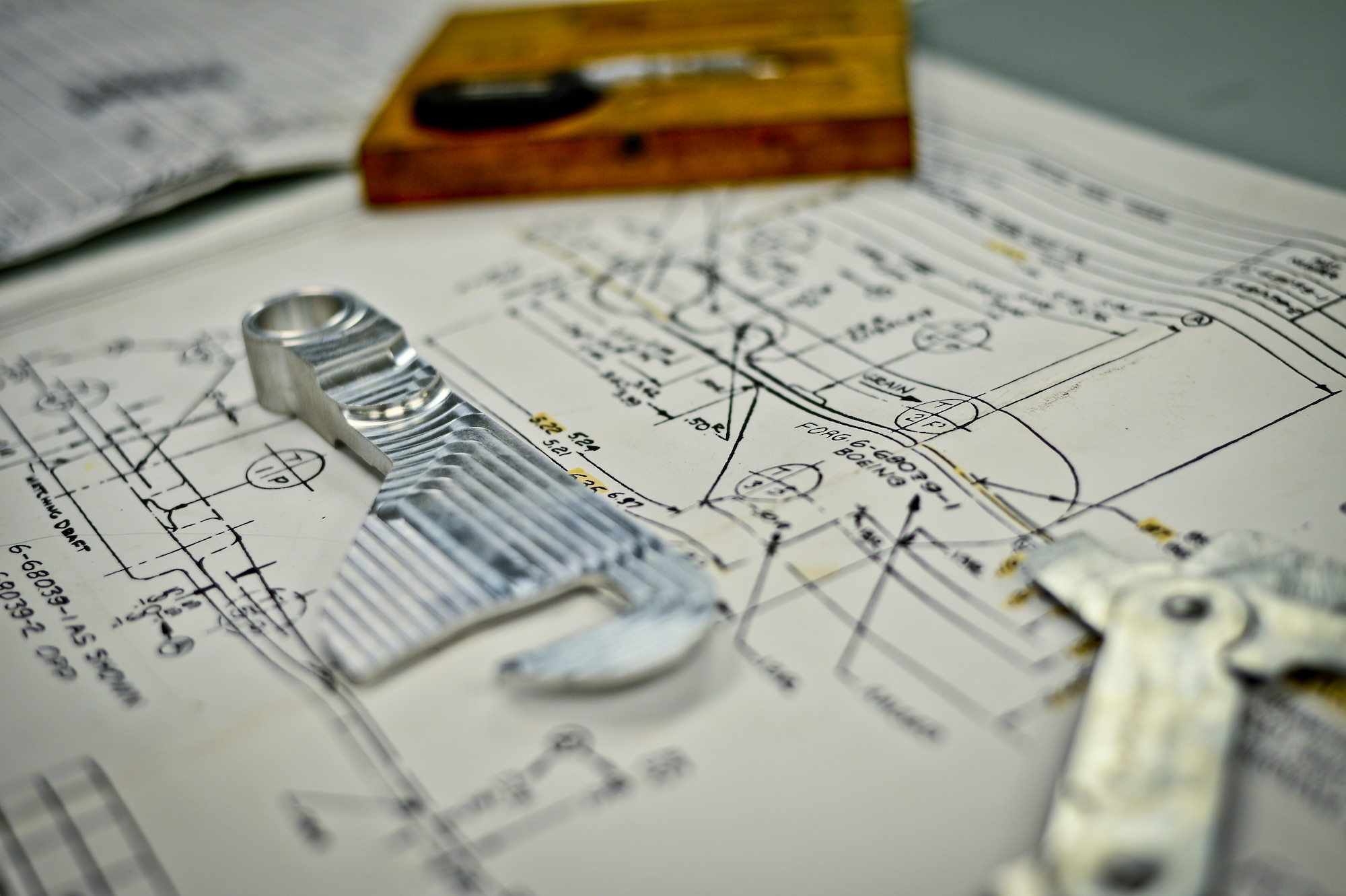 Blueprints, measurement tools, and a completed fabrication part sit on a viewing table at MacDill Air Force Base, Fla., Nov. 5, 2013. This year alone, members of 6th Air mobility Wing’s fabrication flight have save hundreds of thousands of dollars by locally manufacturing parts and tools for the Air Force. (U.S. Air Force photo by Staff Sgt. Brandon Shapiro/Released)