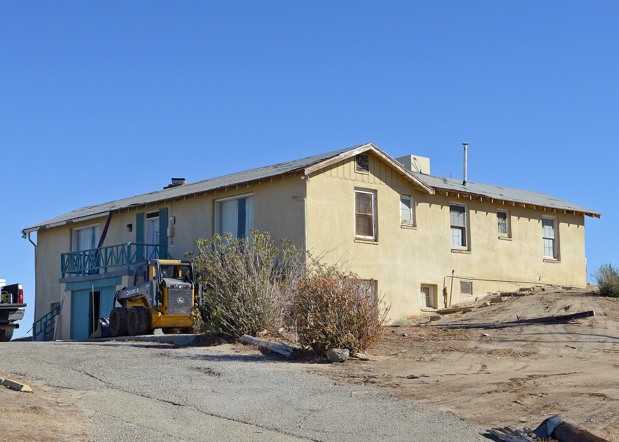 Demolition crews can be seen in front of Muroc Manor, which was the original home of the commanding general of Muroc Army Airfield. The building was constructed in 1943 and is important because it served as the social hub for the base and played host to aviation pioneers and the Hollywood elite during the golden age of flight test at Edwards. Due to the time the building spent unused and weather beaten by the elements, the building was scheduled to be demolished. (U.S. Air Force photo by Jet Fabara)