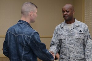 America's Got Talent contestant Jimmy Rose shakes hands with Master Sgt. Julius Walker, 437th Maintenance Squadron resource advisor,  Nov. 15, 2013, at Joint Base Charleston – Air Base, S.C. Rose, a country singer, songwriter and guitarist, finished in 3rd place on the shows eighth season. Rose is a U.S. Marine veteran originally from Pineville, Ky.(U.S. Air Force photo/ Airman 1st Class Chacarra Neal)
