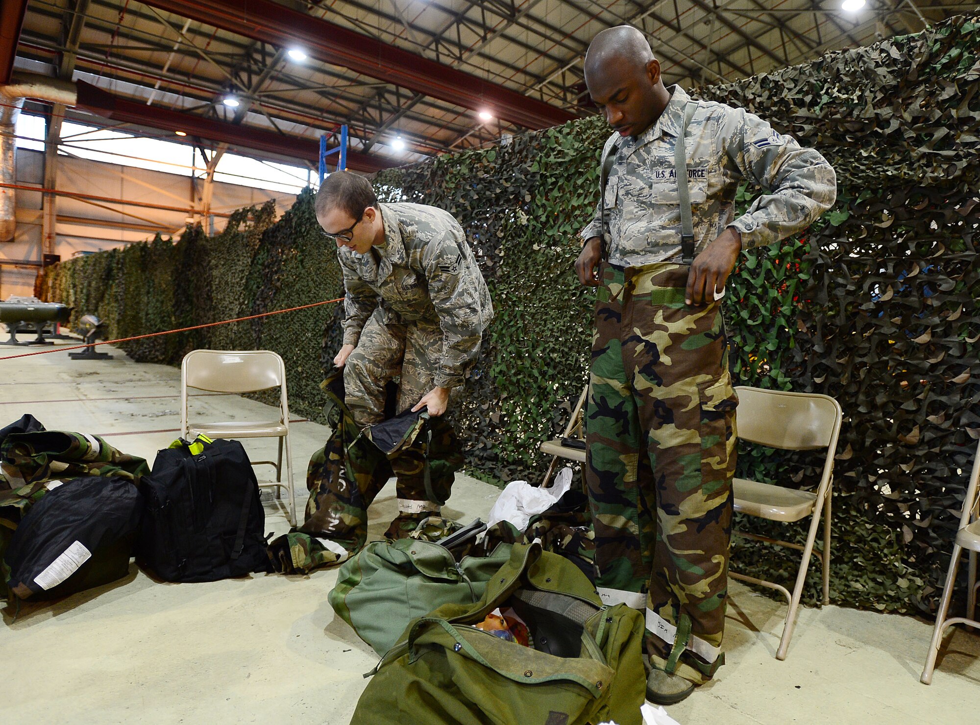Airman 1st Class Brandon Parsons (left), 48th Force Support Squadron fitness center apprentice, and Airman 1st Class Akeem Sims, 48th FSS assignment counselor, don their Mission Oriented Protective Posture gear during a Phase II exercise at Royal Air Force Lakenheath, England, Nov. 20, 2013. The exercise tested the 48th Fighter Wing’s ability to support NATO contingency operations.  (U.S. Air Force photo by Senior Airman Tiffany M. Grigg/Released) 