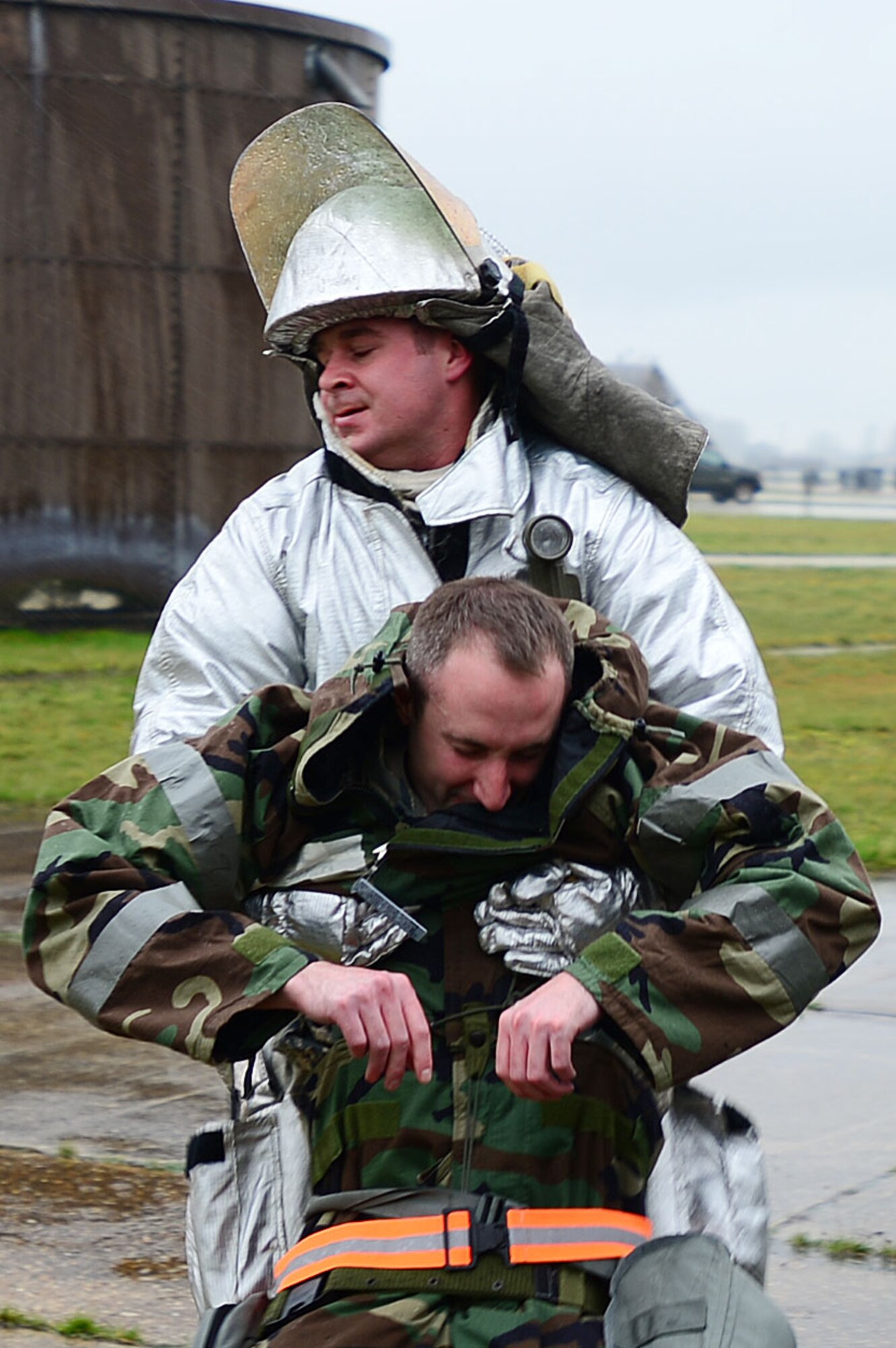 Staff Sgt. Reed Robertson, 48th Civil Engineer Squadron firefighter, carries Capt. Charles Bloemendal, 48th CES readiness emergency management flight officer, to safety after a simulated building fire during a Phase II exercise at RAF Lakenheath, England, Nov. 20, 2013. One aspect of the Phase II is testing the response capabilities of Airmen through various scenarios to ensure mission readiness.  (U.S. Air Force photo by Senior Airman Tiffany M. Grigg/Released) 