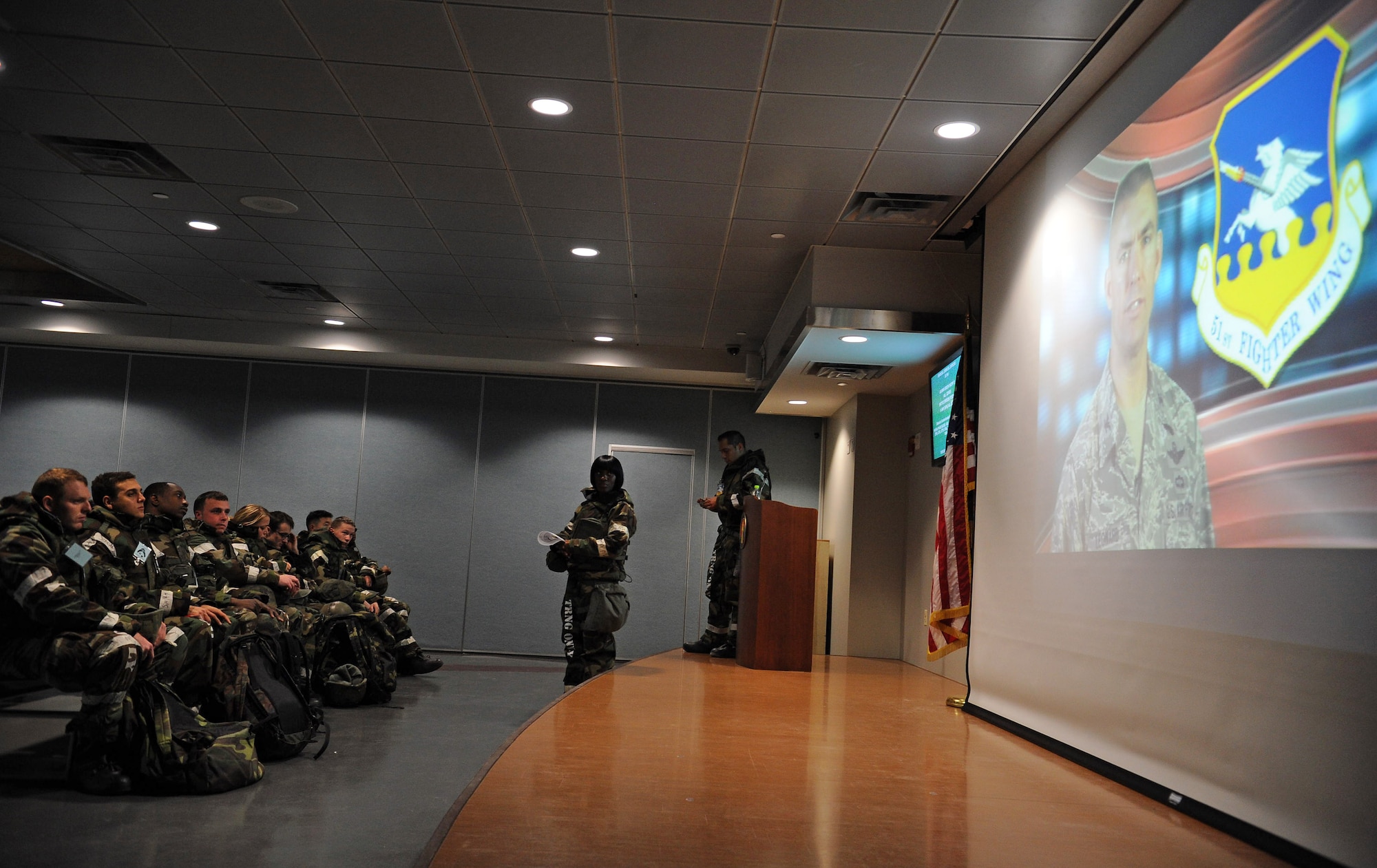 Airmen from the 51st Fighter Wing acting as follow-on forces watch a mission video about the 51st FW during Operational Readiness Exercise Beverly Bulldog 14-01 at Osan Air Base, Republic of Korea, Nov. 21, 2013. The 51st FW will act as the simulated deployees’ new home during the remainder of the ORE. (U.S. Air Force photo/Staff Sgt. Sara Csurilla)