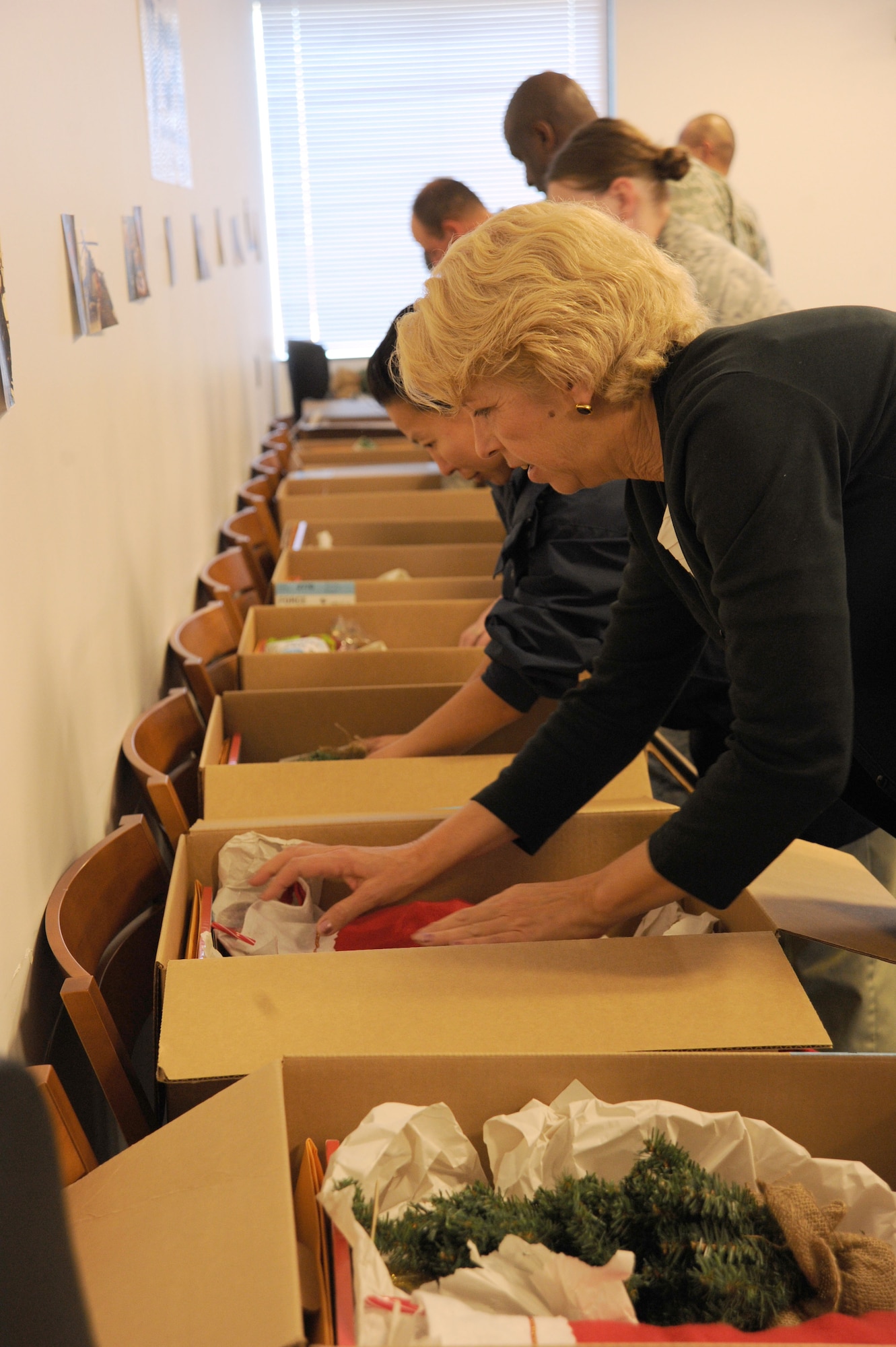 Anita Lamaallem and fellow members of the Air Force District of Washington pack boxes with treats during the unit’s holiday care package packing event at Joint Base Andrews, Md., Nov. 19, 2013. The group filled 25 boxes for Airmen deployed from the unit with donations ranging from gingerbread houses to canned snow. Lamaallem works AFDW logistics support agreements and plans. (U.S. Air Force photo/Tech. Sgt. Tammie Moore)