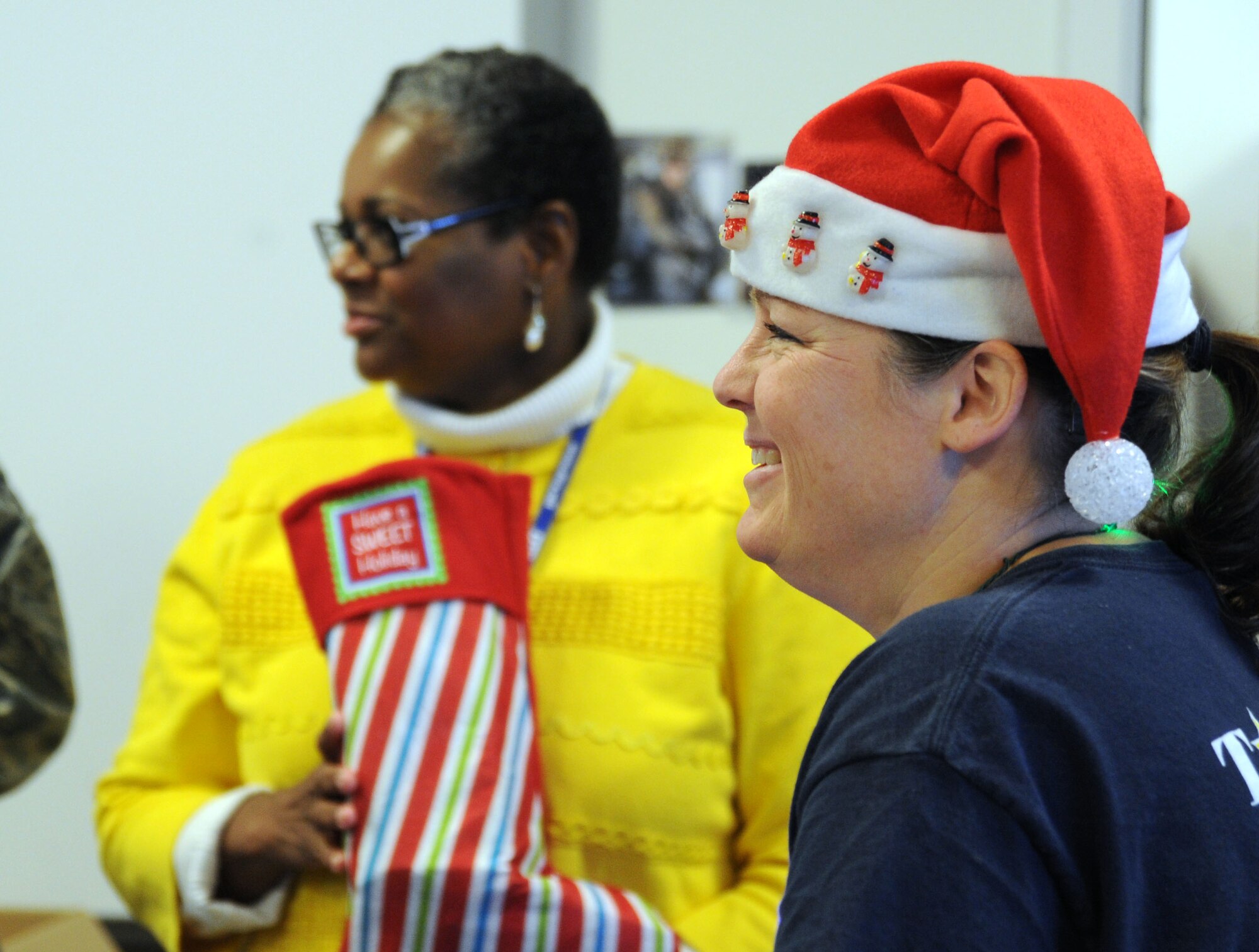 Annette Bonaro smiles as she watches members of the Air Force District of Washington fill stockings during the unit’s holiday care package packing event at Joint Base Andrews, Md., Nov. 19, 2013. Bonaro, AFDW unit deployment manager, carefully coordinated the collection, packaging and mailing of the holiday care packages for each of the Airmen she deployed. (U.S. Air Force photo/Tech. Sgt. Tammie Moore)