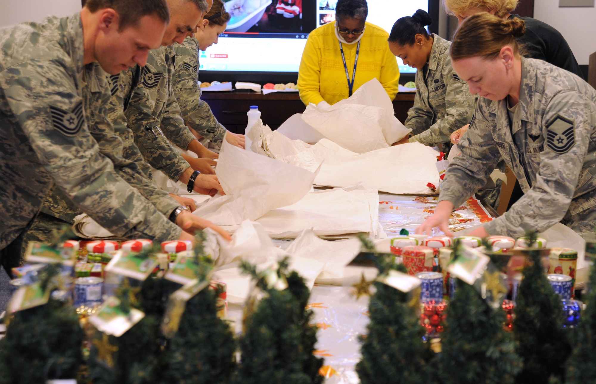 Members of the Air Force District of Washington wrap fragile items during the unit’s holiday care package packing event at Joint Base Andrews, Md., Nov. 19, 2013. The group filled boxes for Airmen deployed from the unit with donations ranging from gingerbread houses to canned snow. (U.S. Air Force photo/Tech. Sgt. Tammie Moore)