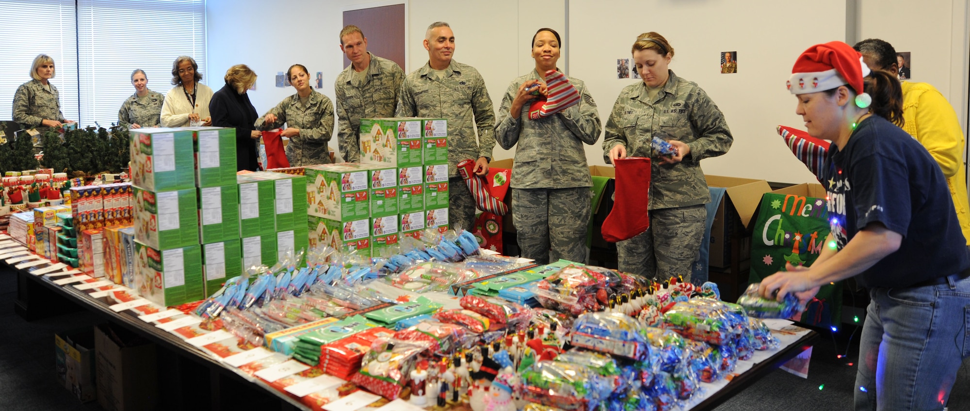 Members of the Air Force District of Washington stuff treats into stockings during the unit’s holiday care package packing event at Joint Base Andrews, Md., Nov. 19, 2013. The group filled boxes for Airmen deployed from the unit with donations ranging from gingerbread houses to canned snow. (U.S. Air Force photo/Tech. Sgt. Tammie Moore)