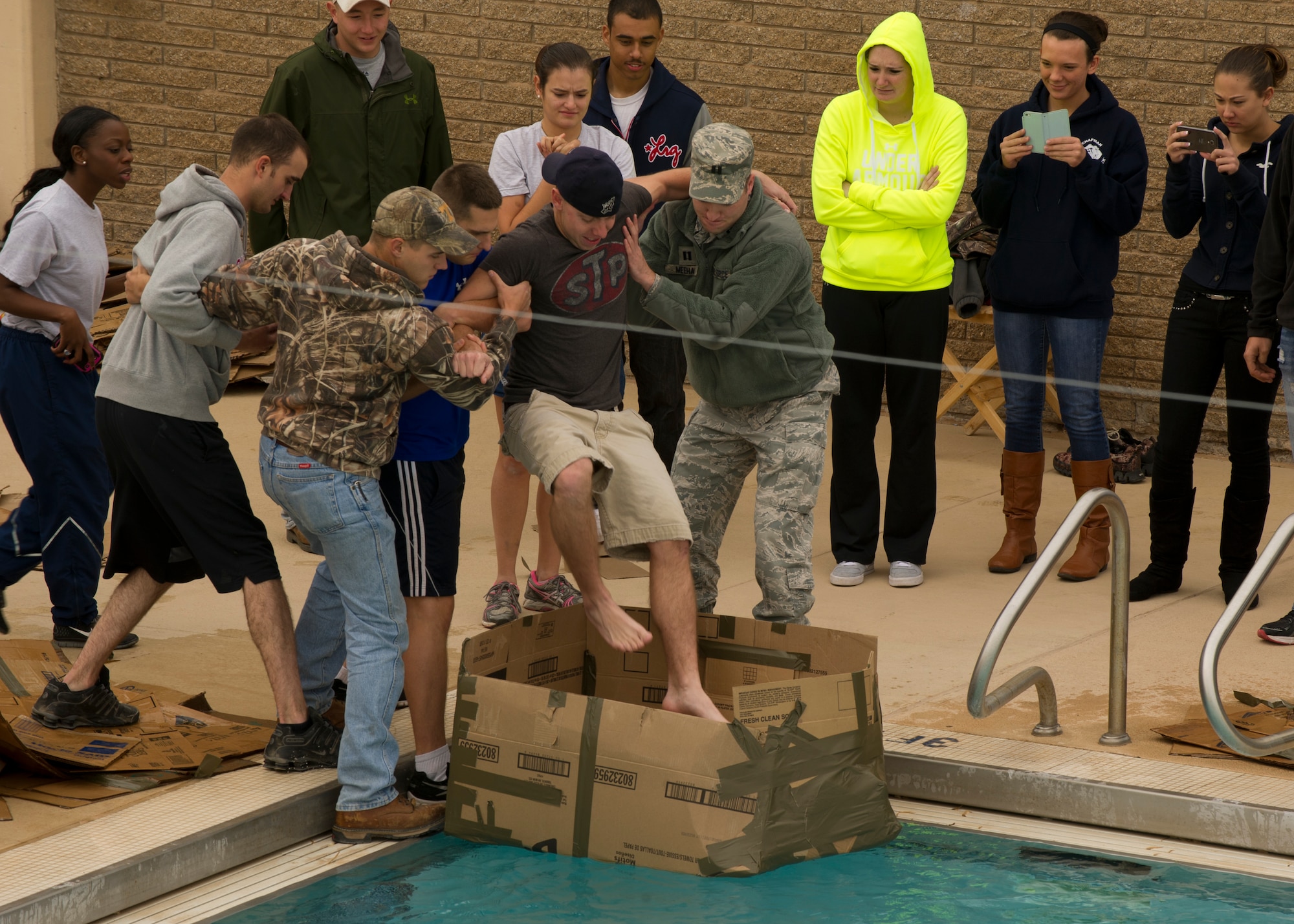Members of Team Holloman hoist their fellow Airman into a cardboard boat in an attempt to win this Sports Day at Holloman Air Force Base N.M., Nov. 15. Sports Day is an annual event held through the Domenici Fitness and Sports Center, in which Holloman units compete against one another in various team and individual events. (U.S. Air Force photo by Airman 1st Class Chase Cannon/Released)
