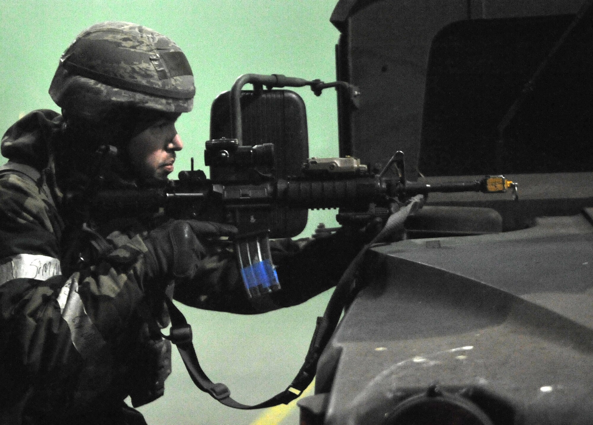 A defender from the 51st Security Forces Squadron watches out for simulated approaching enemy forces during Operational Readiness Exercise Beverly Bulldog 14-01 at Osan Air Base, Republic of Korea, Nov. 20, 2013. Airmen concealed themselves behind tactical vehicles and laid down cover fire while others pursued opposition forces members that had breached the perimeter. (U.S. Air Force photo/Airman 1st Class Ashley J. Thum) 