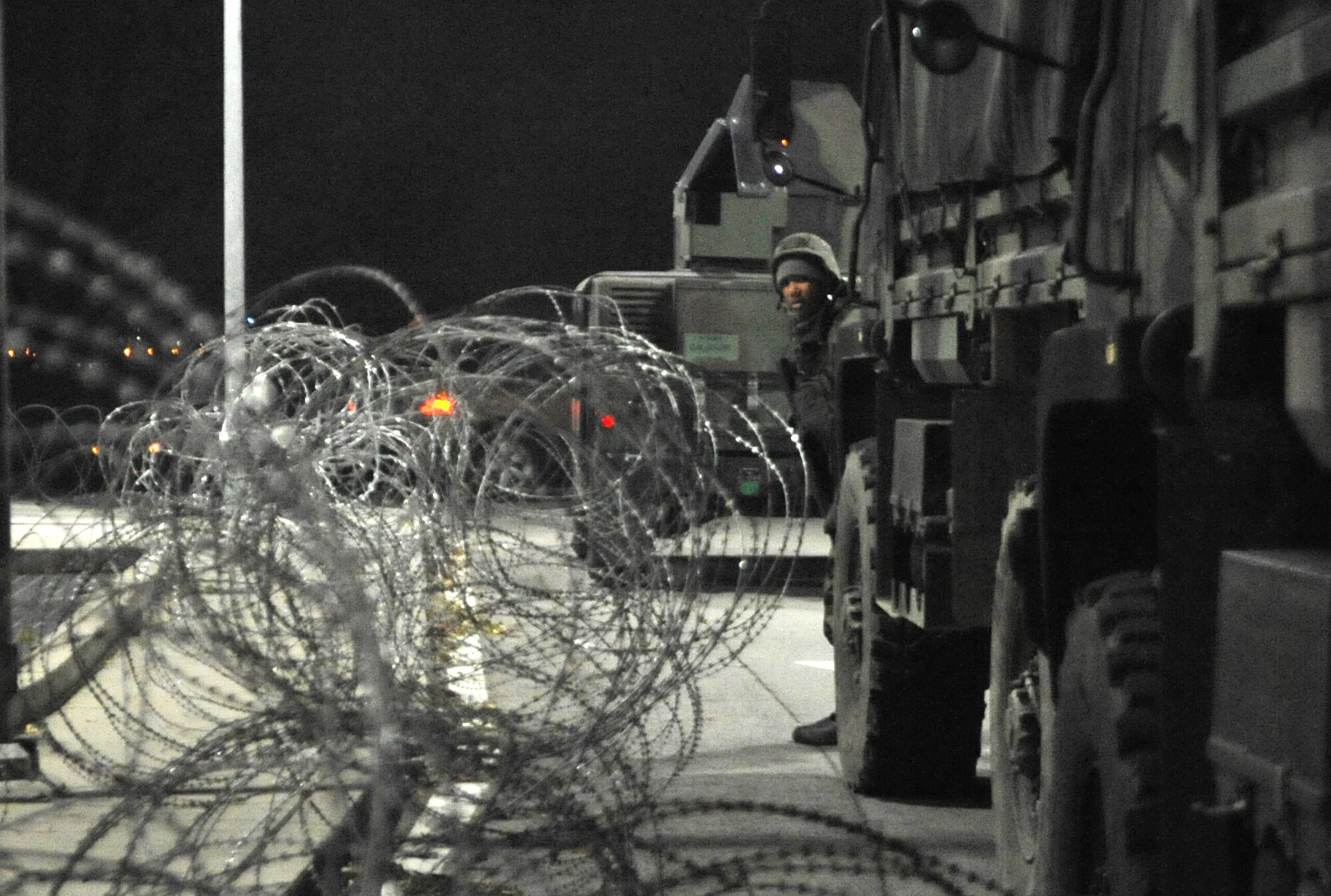A 51st Security Forces Squadron Airman takes a look around the corner of a tactical vehicle used as concealment during Operational Readiness Exercise Beverly Bulldog 14-01 at Osan Air Base, Republic of Korea, Nov. 20, 2013. Defenders used tactical vehicles during the attack scenario to form a defensive fighting position. (U.S. Air Force photo/Airman 1st Class Ashley J. Thum)