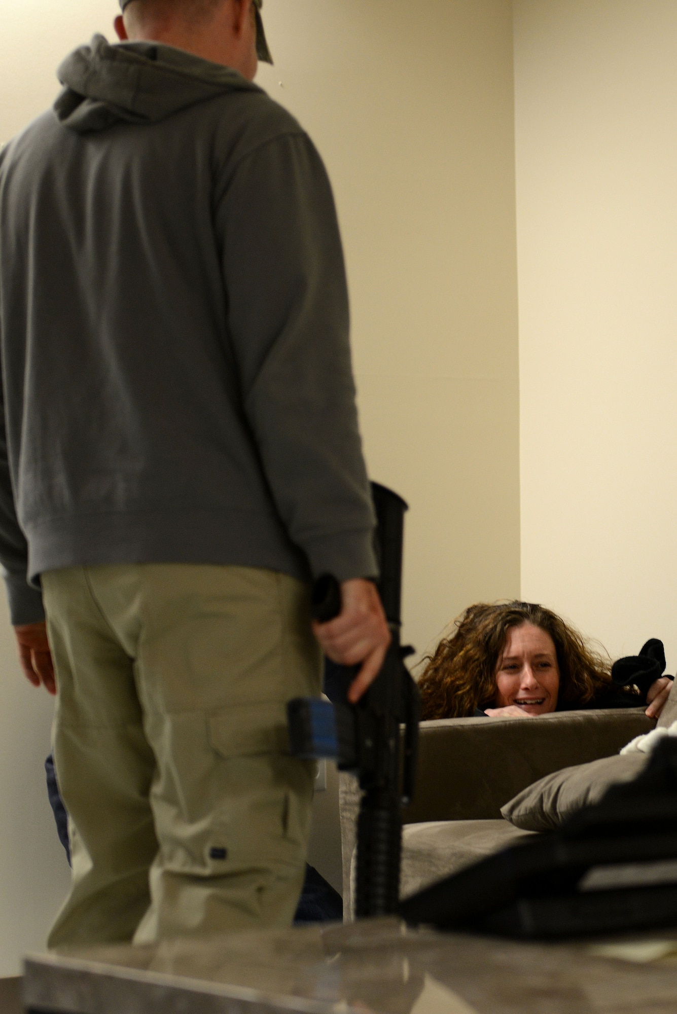 U.S. Air Force Tech. Sgt. Jennifer Gemmell, 633rd Communications Squadron quality assurance evaluator, hides in a corner of a dormitory day room during a simulated hostage situation at Langley Air Force Base, Va., Nov. 19, 2013. Gemmell was taken hostage by an Airman simulating post-traumatic stress disorder after his recent deployment to Afghanistan. (U.S. Air Force photo by Airman 1st Class Kimberly Nagle/Released)