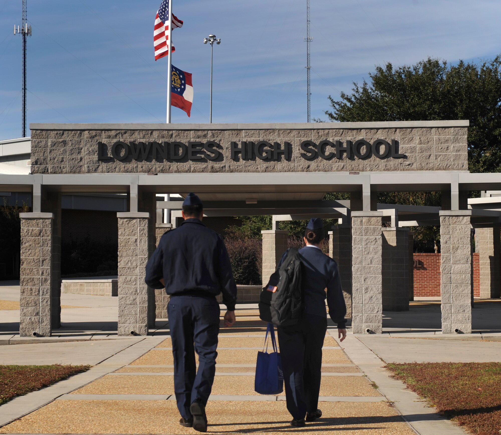 U.S. Air Force 1st Lt. Myles Morales and Staff Sgt. Regina Cooper, 336th Recruiting Squadron, walk toward the Lowndes High School entrance in Valdosta, Ga., Nov. 13, 2013. Morales and Cooper spoke to Junior ROTC students about Air Force commissioning opportunities available. (U.S. Air Force photo by Senior Airman Olivia Bumpers/Released)