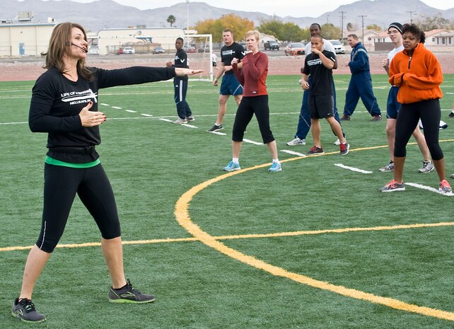 Missy Cornish, wife of Col. Barry Cornish, 99th Air Base Wing commander, leads a Warrior Trained Fitness workout on the field behind the Warrior Fitness Center Nov. 19, 2013, at Nellis Air Force Base, Nev. Warrior Trained Fitness is a high intensity interval training workout designed as a part of the “Life of a Warrior” concept of living a healthier lifestyle. (U.S. Air Force photo by Senior Airman Matthew Lancaster)