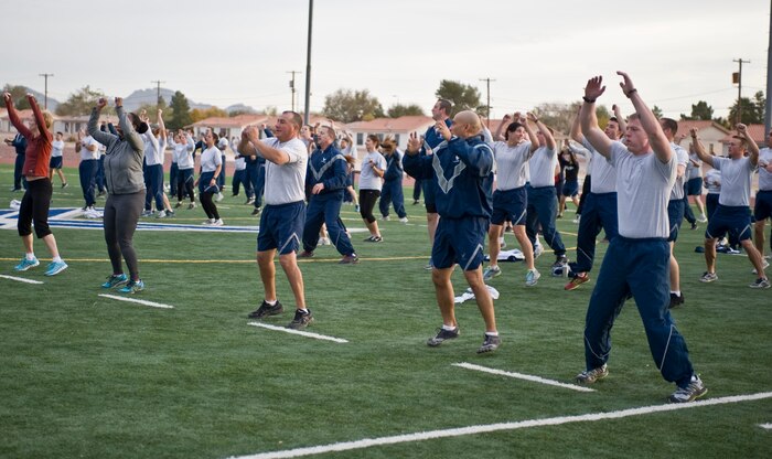 Participants of the Warrior Trained Fitness workout do warm up exercises on the field behind the Warrior Fitness Center Nov. 19, 2013, at Nellis Air Force Base, Nev. The warrior trained fitness work out is a part of the “Life of a Warrior” concept which encourages a lifestyle incorporating good nutrition, healthy habits and a positive outlook. (U.S. Air Force photo by Senior Airman Matthew Lancaster)