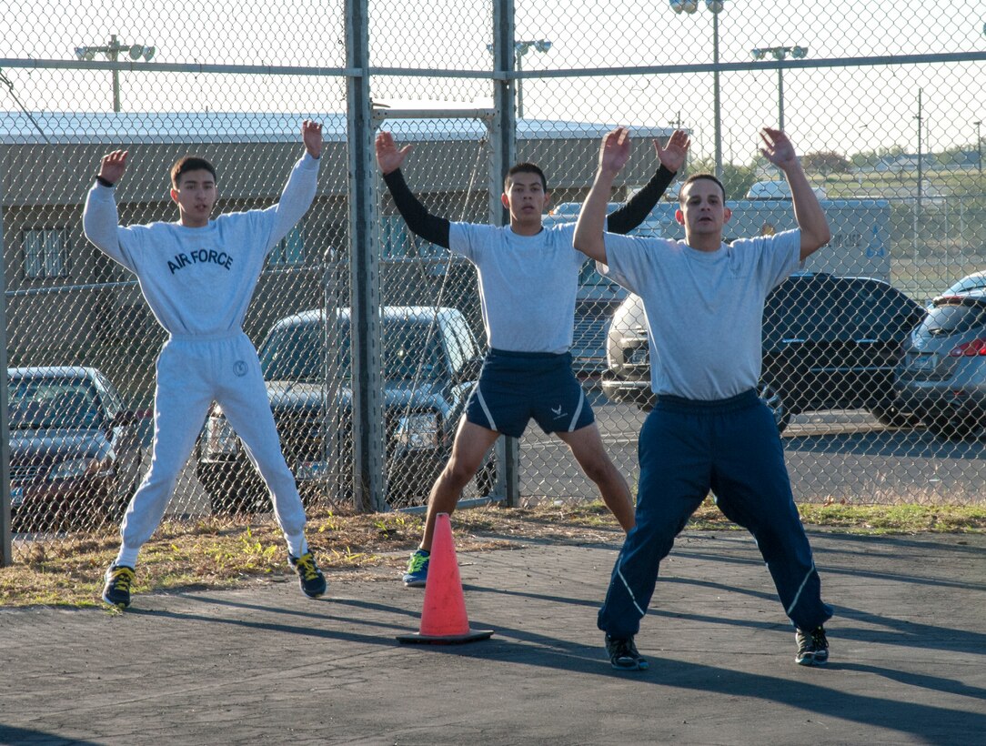 First Lt. Christian Ocasio, right, Laughlin Company Grade Officers' Council treasurer, joins his Air Force Junior ROTC group in jumping jacks at Del Rio High School, Texas, Nov. 15, 2013. The CGOs do a combination of cardio and calisthenics each week with Junior ROTC. (U.S. Air Force photo/2nd Lt. William M. Tyrrell)