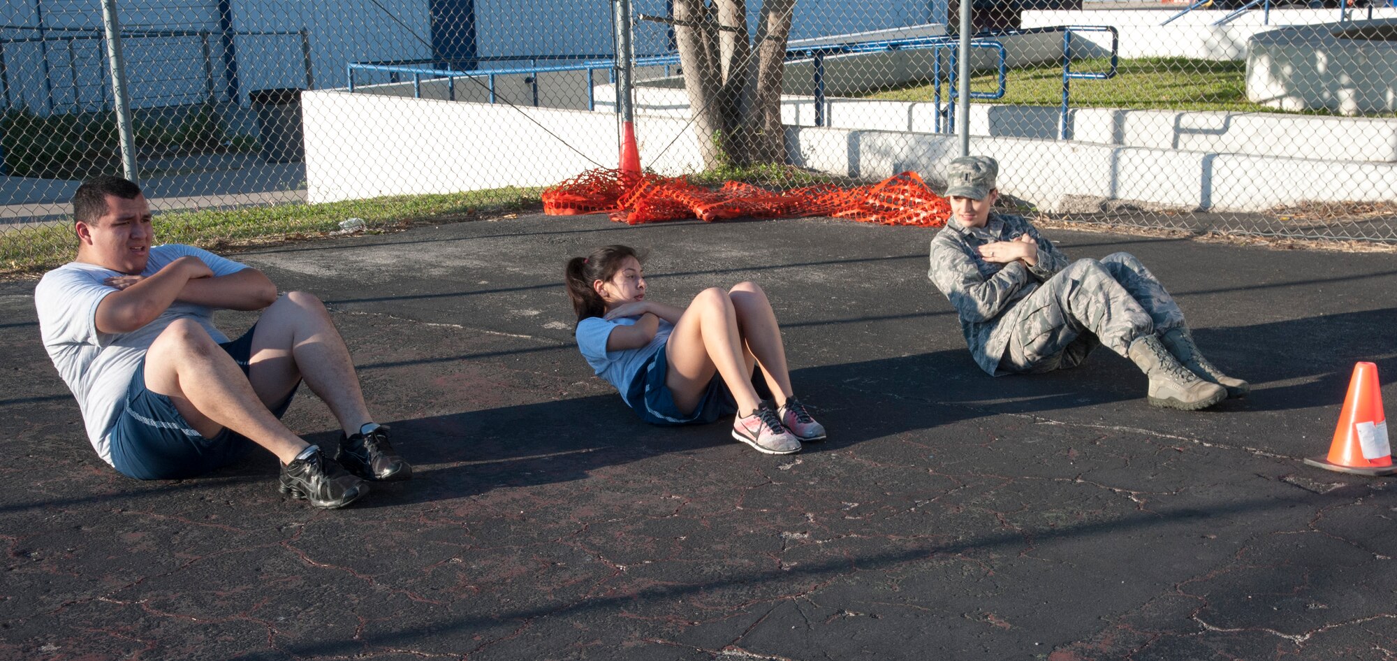 First Lt. Laura Watson, right, Laughlin Company Grade Officers' Council vice president, pushes the Air Force Junior ROTC to their physical limits during the sit-up station at Del Rio High School, Texas, Nov. 15, 2013. By joining the students, she is able to motivate them to keep going even when they are tired. (U.S. Air Force photo/2nd Lt. William M. Tyrrell)
